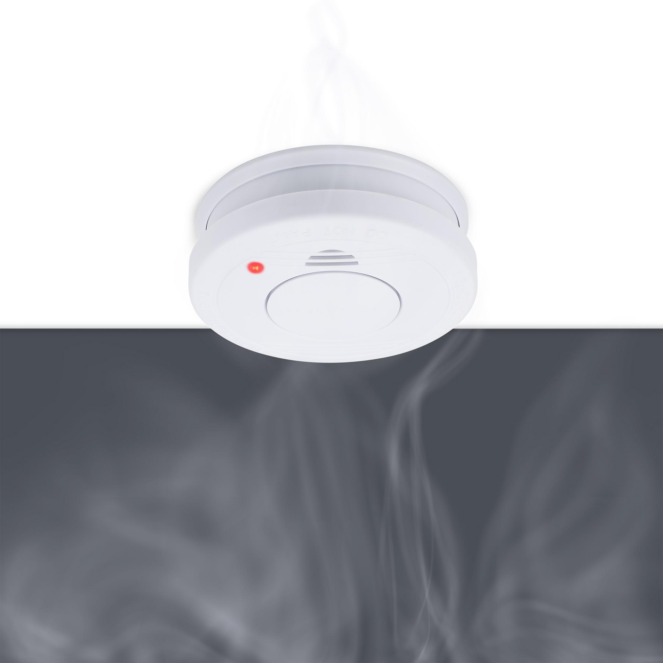 Biała czujka dymu z czerwonym światłem i dymem wznoszącym się na białym i szarym tle.