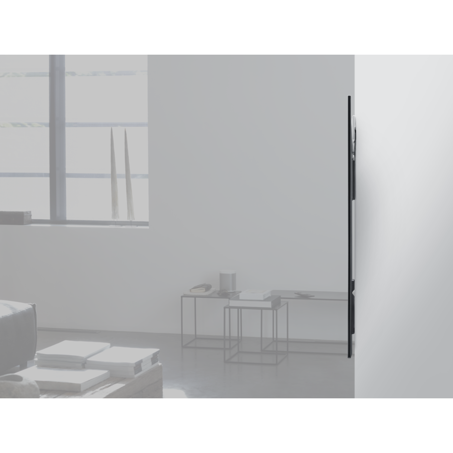 Modern TV on wall. Black screen. White background with tables.