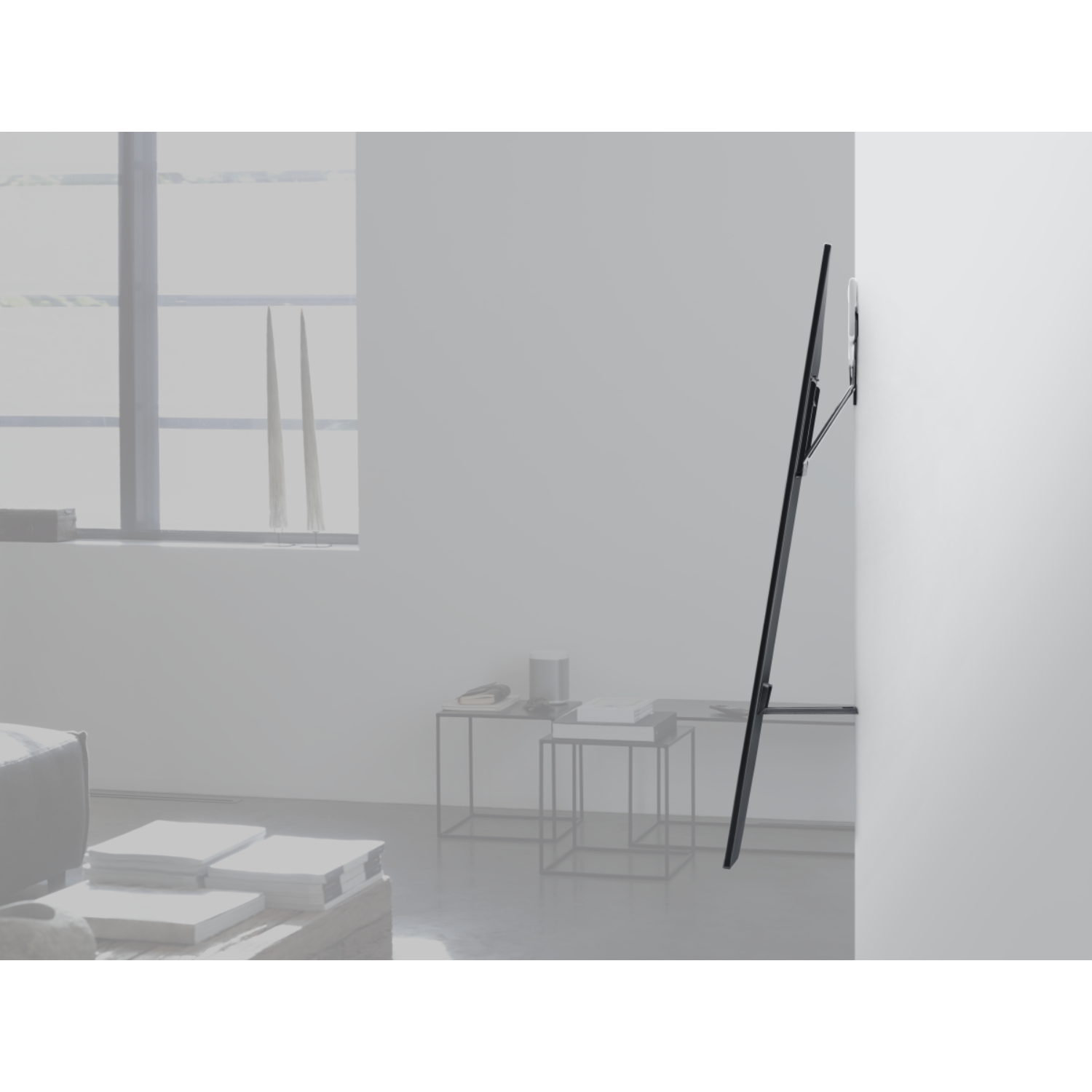 A black TV mounted on a white wall, with a minimalist decor.