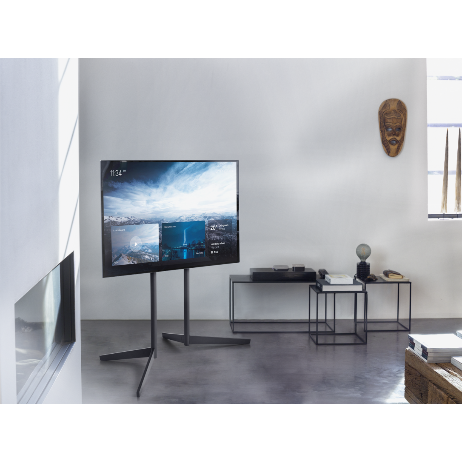 Ein modernes Wohnzimmer mit einem Fernseher auf einem Ständer. Es gibt einen Kamin und eine Maske.