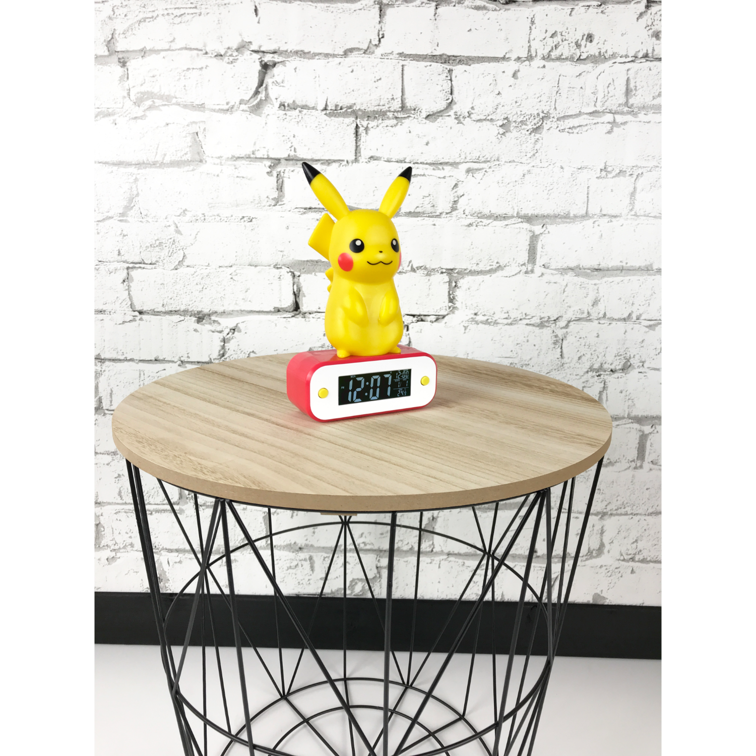 Orologio di Pikachu su un tavolo. Il tavolo ha una struttura in metallo nero e un piano in legno.