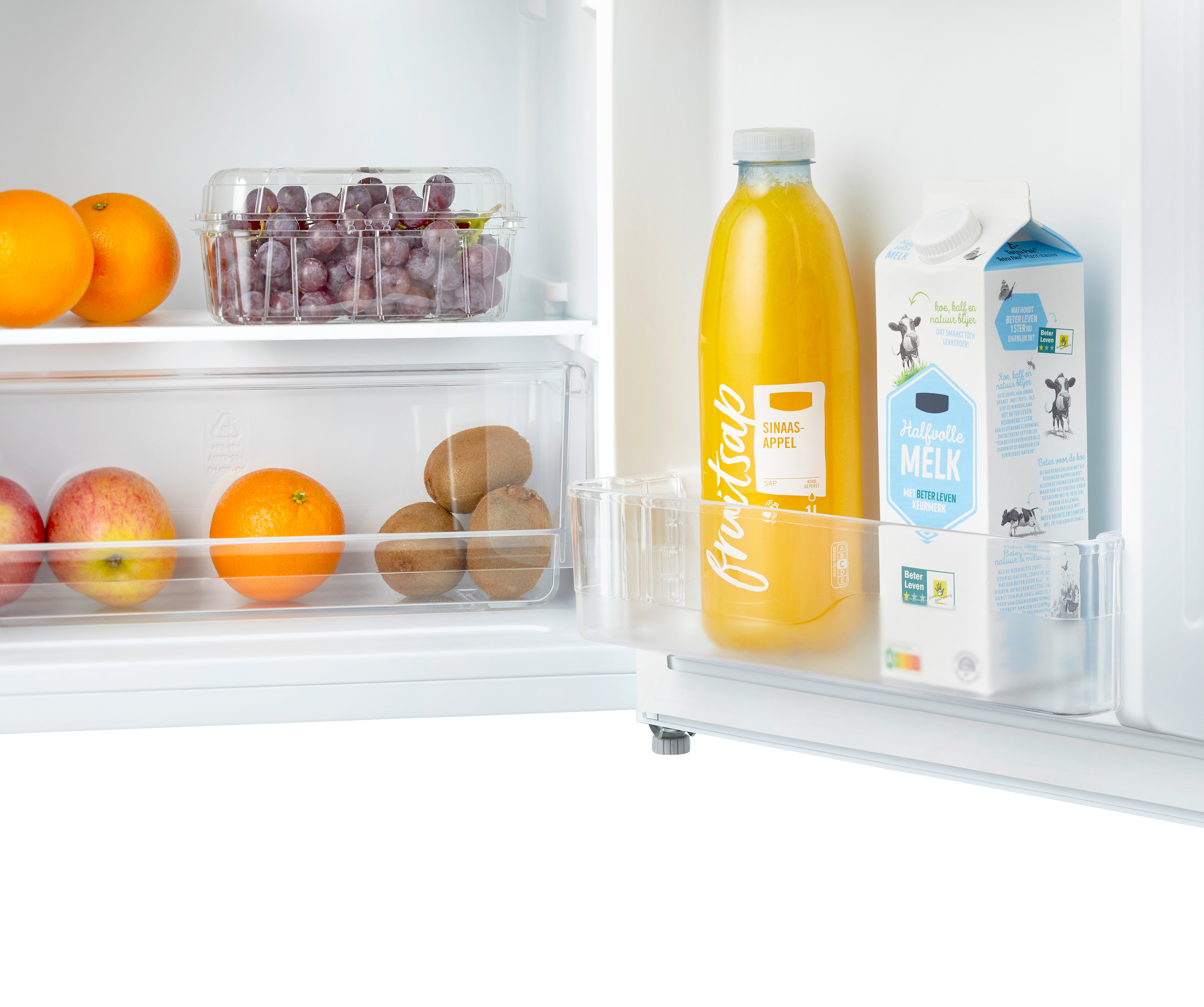 Intérieur du réfrigérateur : fruits, jus et briques de lait sur les étagères.