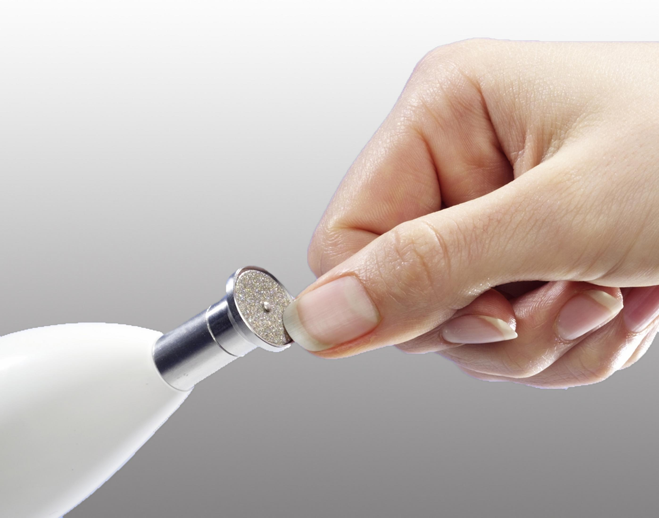 Hand, die ein Beauty-Tool hält, der Kopf des Tools wird im Nahaufnahme gezeigt.