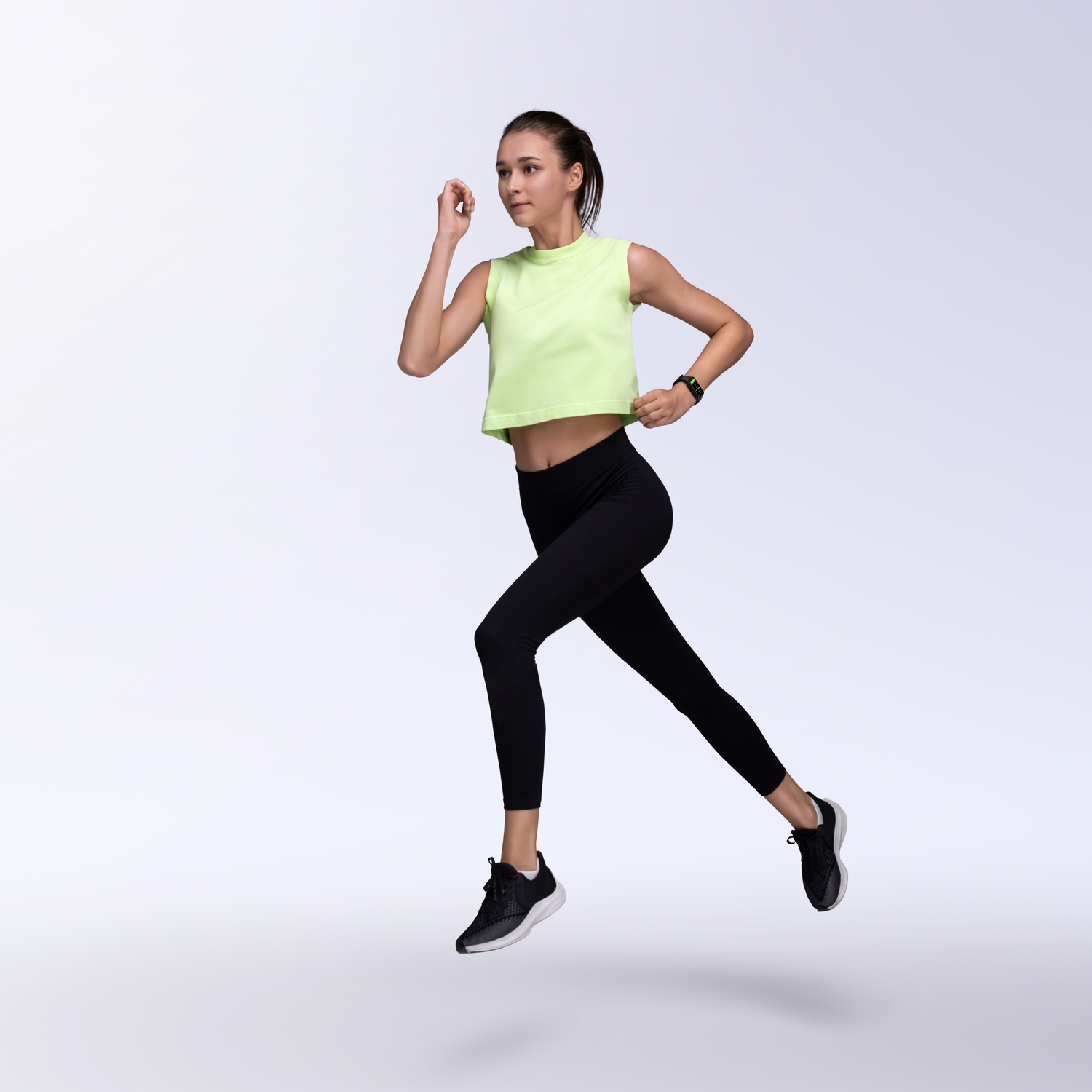 Mujer corriendo en ropa deportiva. Top amarillo, leggings negros. Fondo blanco.