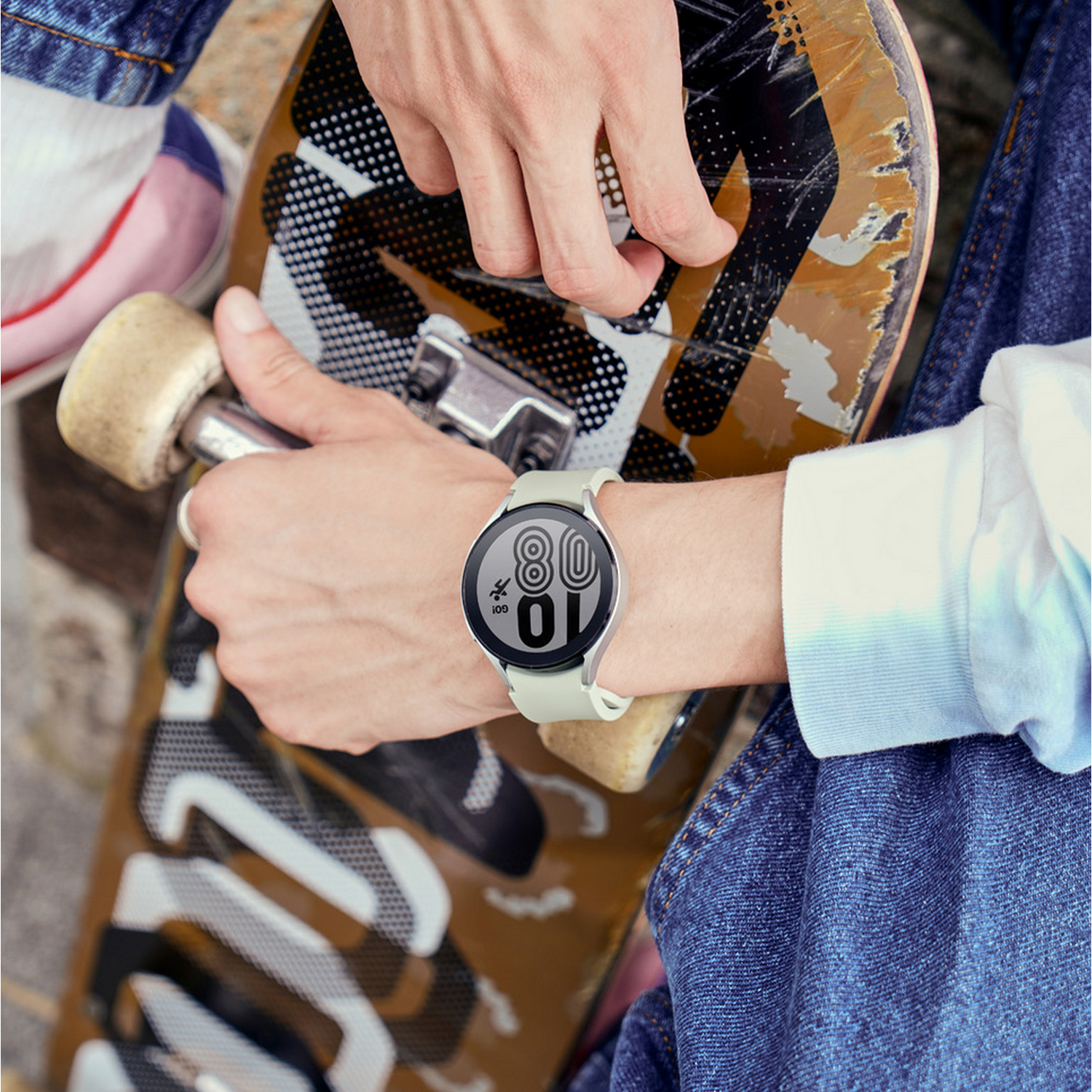 Person trägt Smartwatch, zeigt Zeit. Person steht auf einem Skateboard.