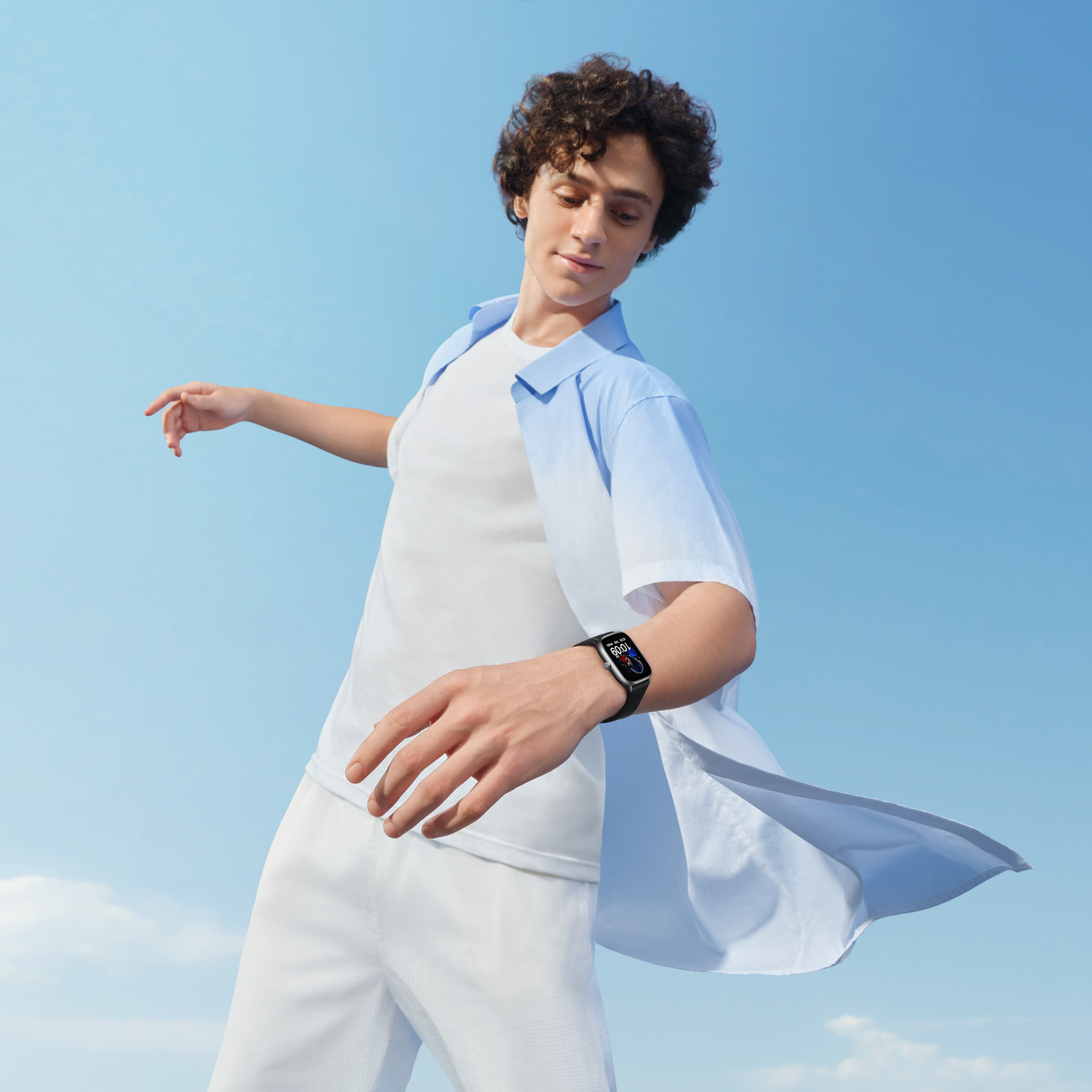 Uomo con smartwatch con sfondo cielo blu, sorridente.
