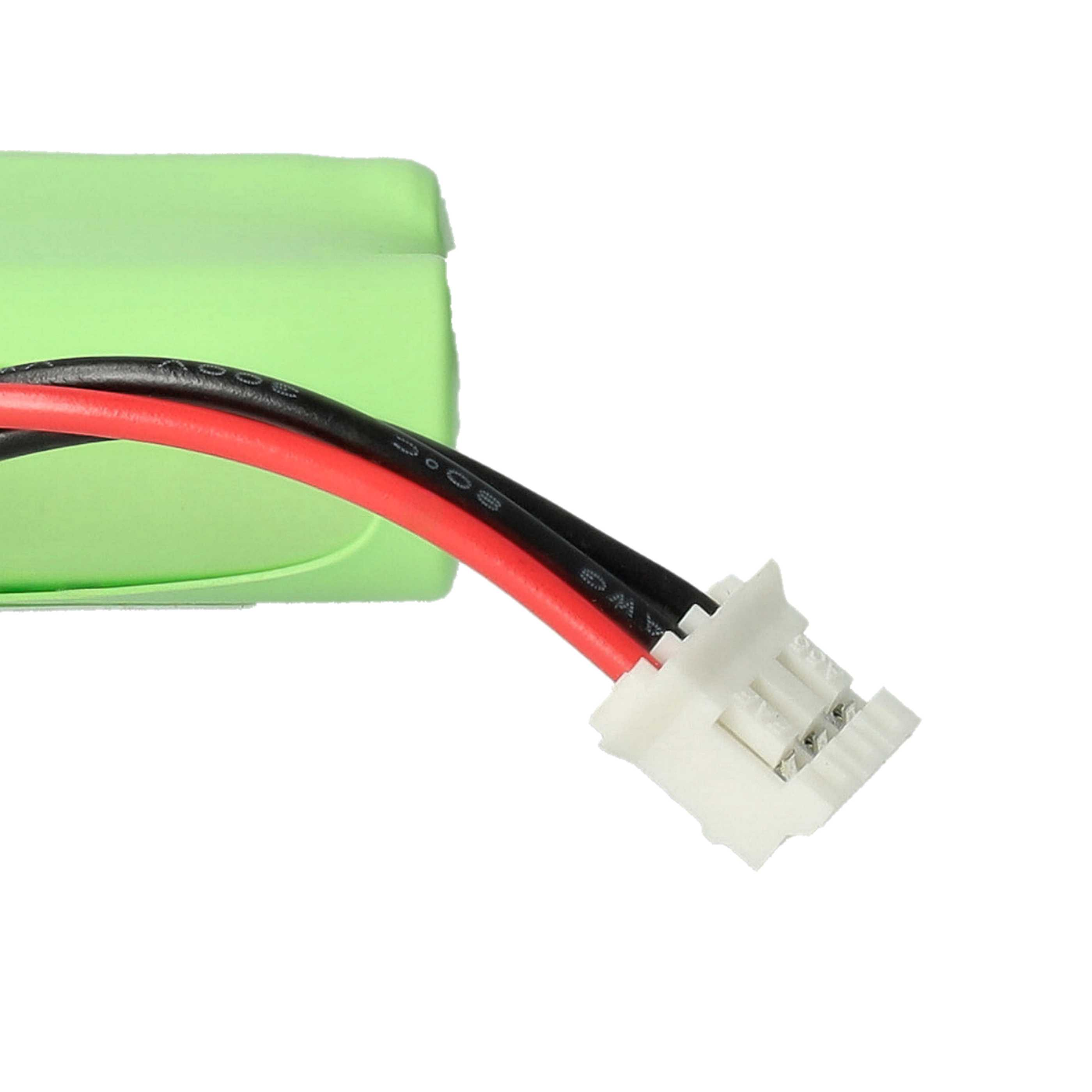 Eine grüne Batterie mit roten und schwarzen Drähten, die an einen weißen Stecker angeschlossen sind.