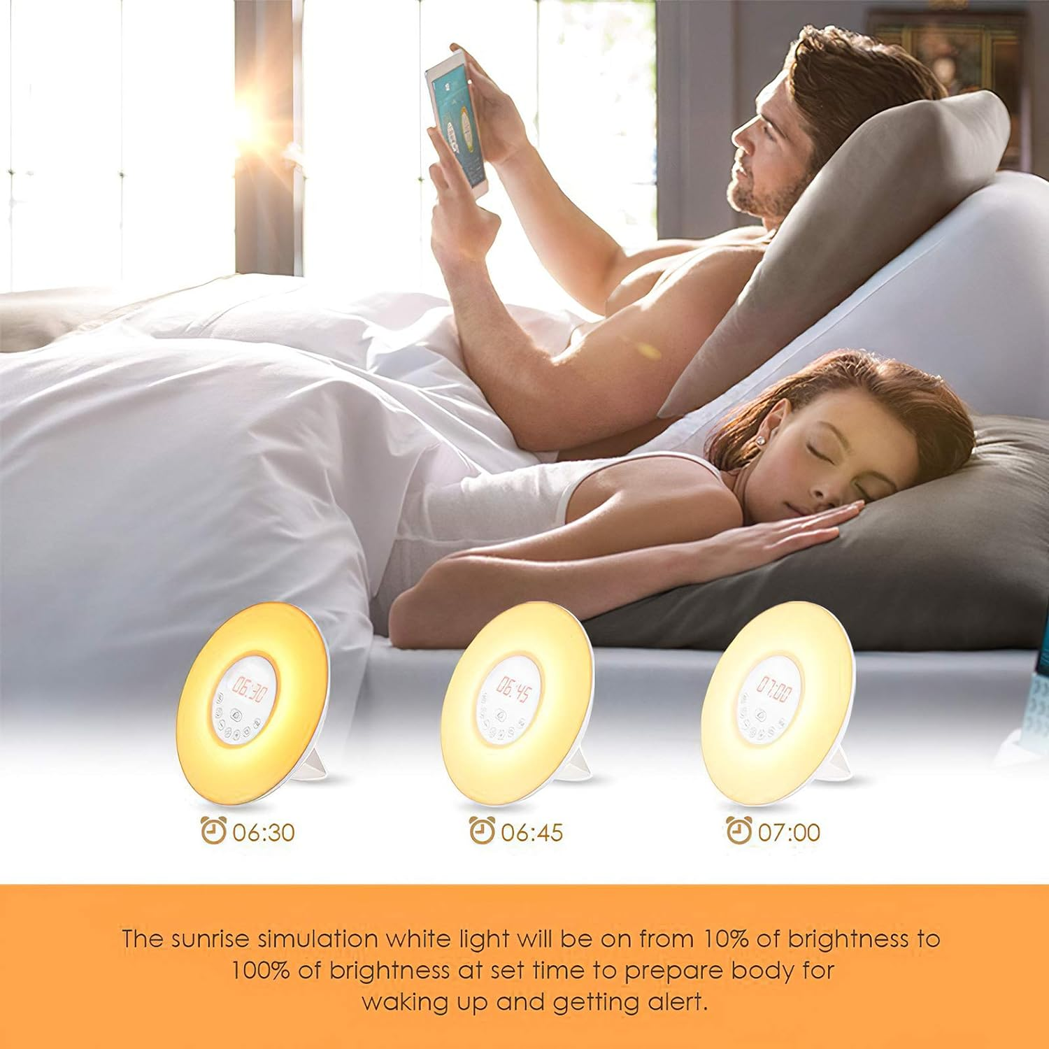 Ein Paar im Bett mit Sonnenaufgangsweckern, eine Person benutzt ein Telefon, die andere schläft.