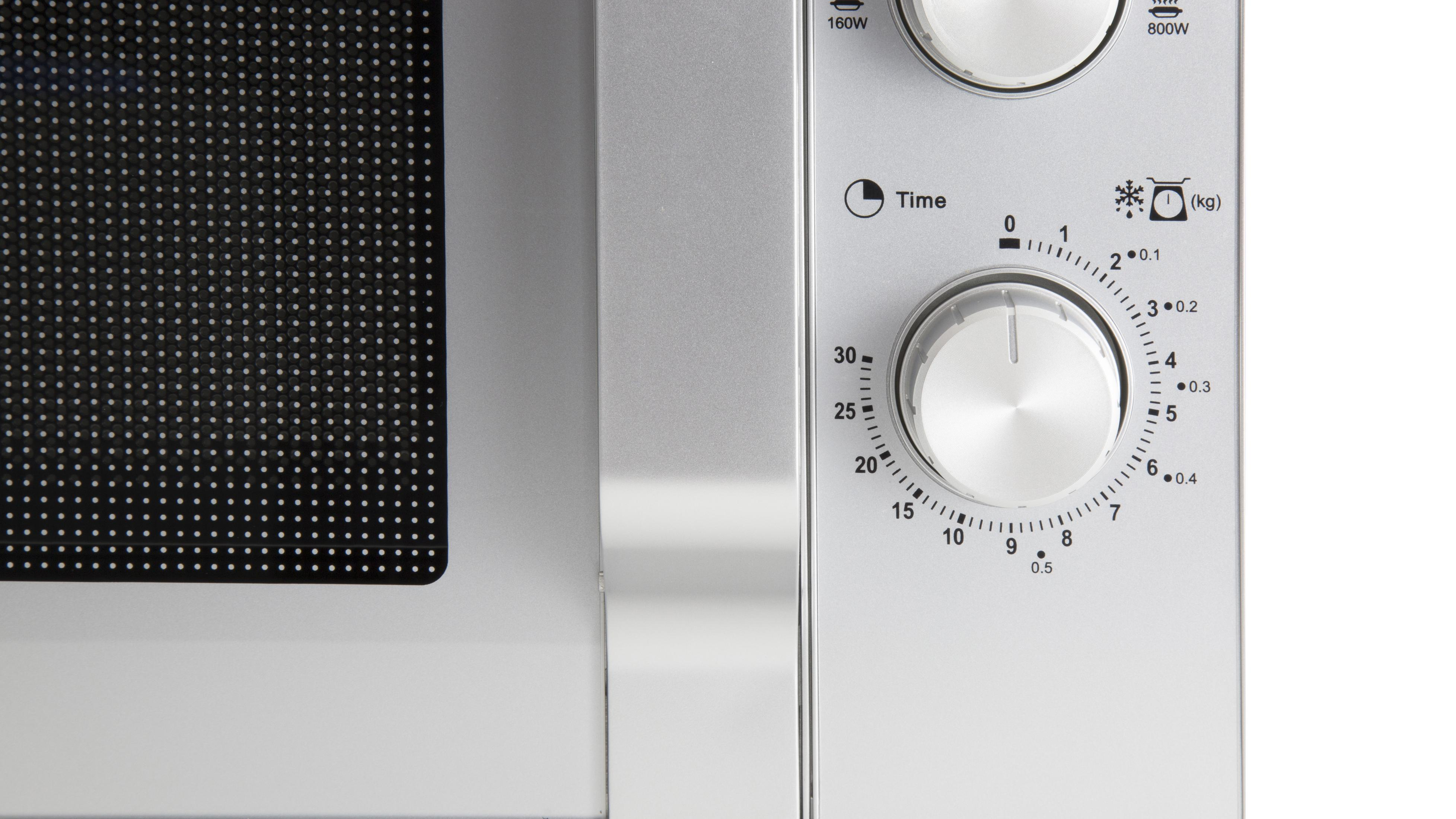 Zbliżenie panelu sterowania kuchenki mikrofalowej z timerem i pokrętłami mocy.