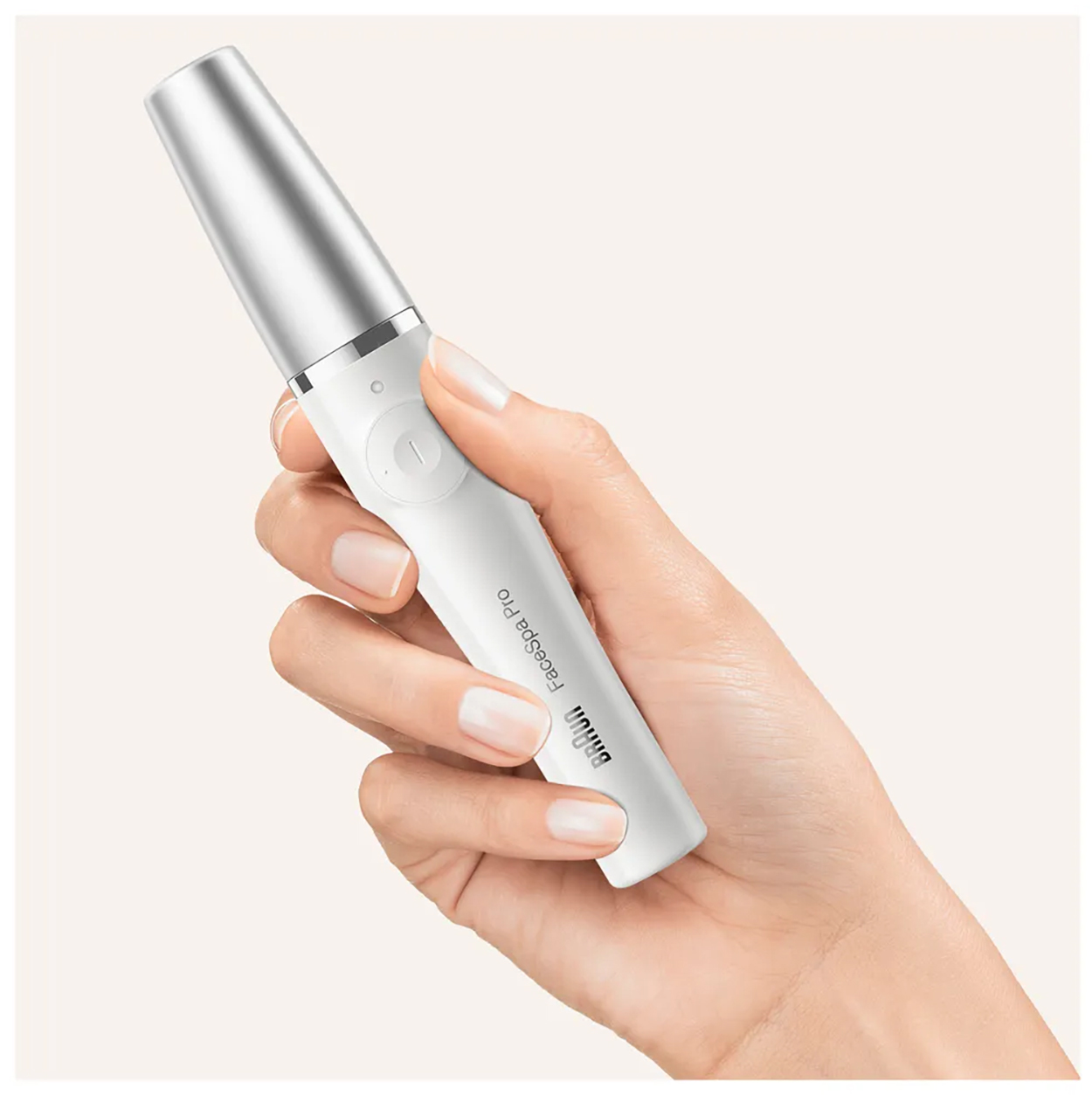 Vrouw die een wit Braun FaceSpa Pro-apparaat vasthoudt; handen en apparaat zichtbaar.