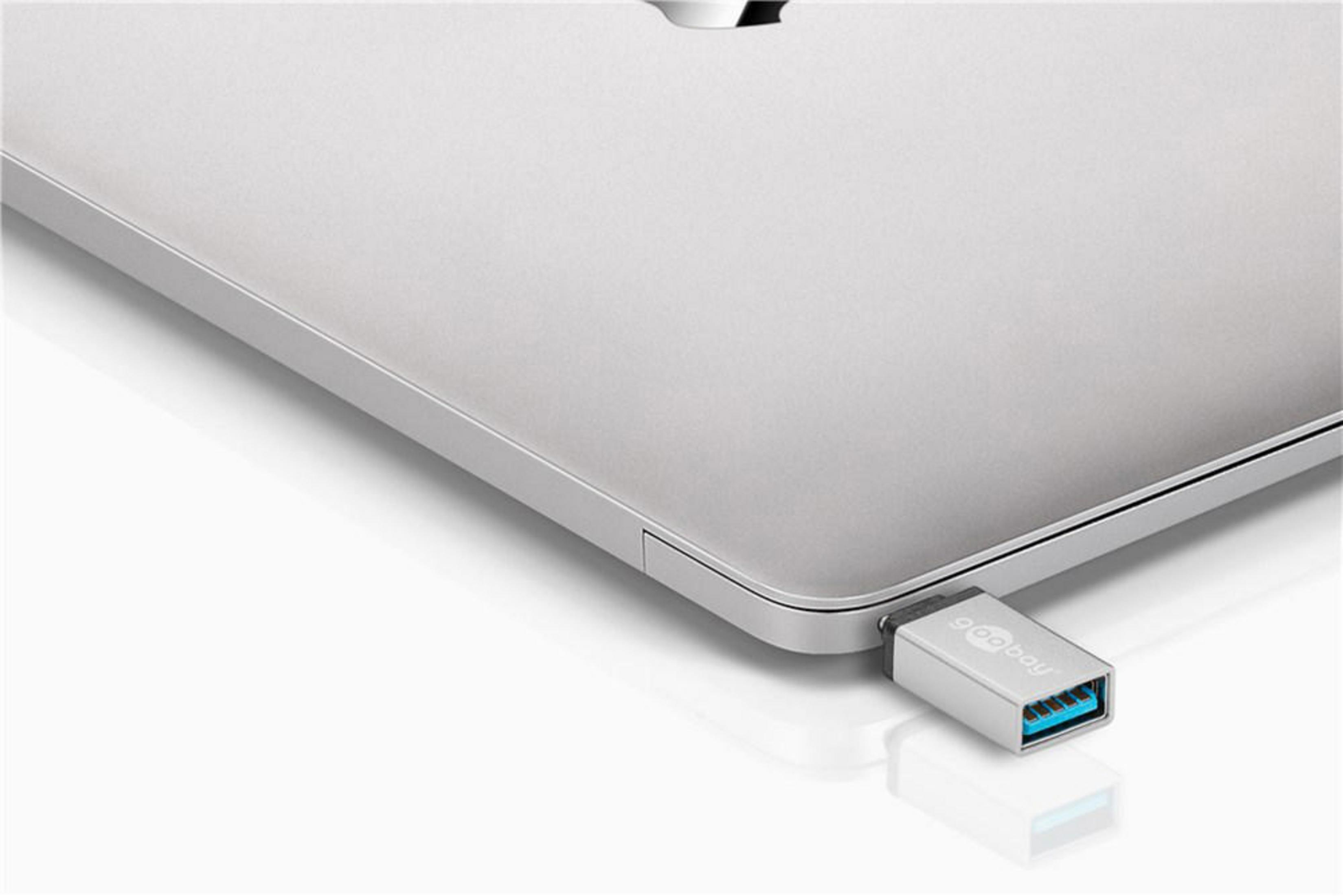 Srebrny adapter USB-A do USB-C podłączony do srebrnego laptopa.