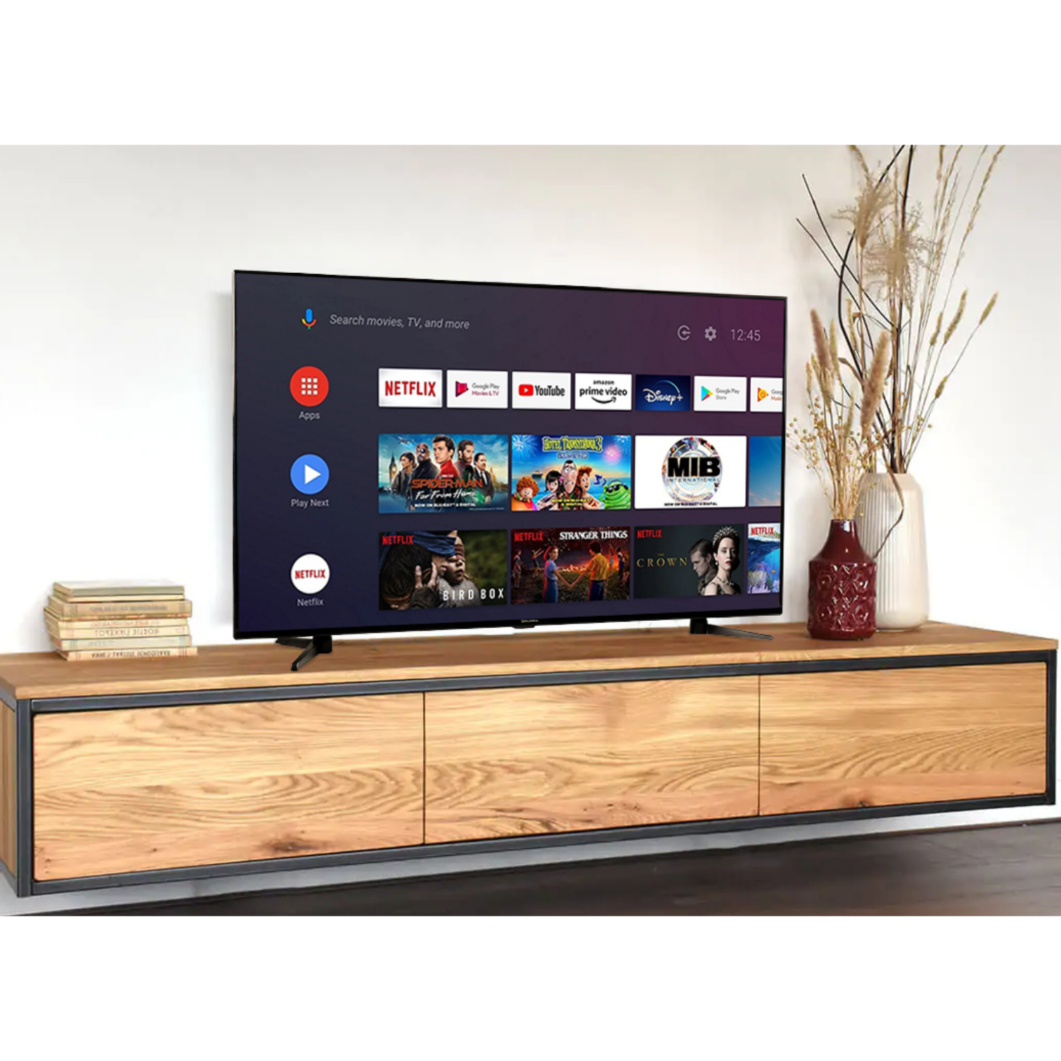 Woonkamer met een tv op een houten kast en decoratieve items. Een witte muur op de achtergrond.