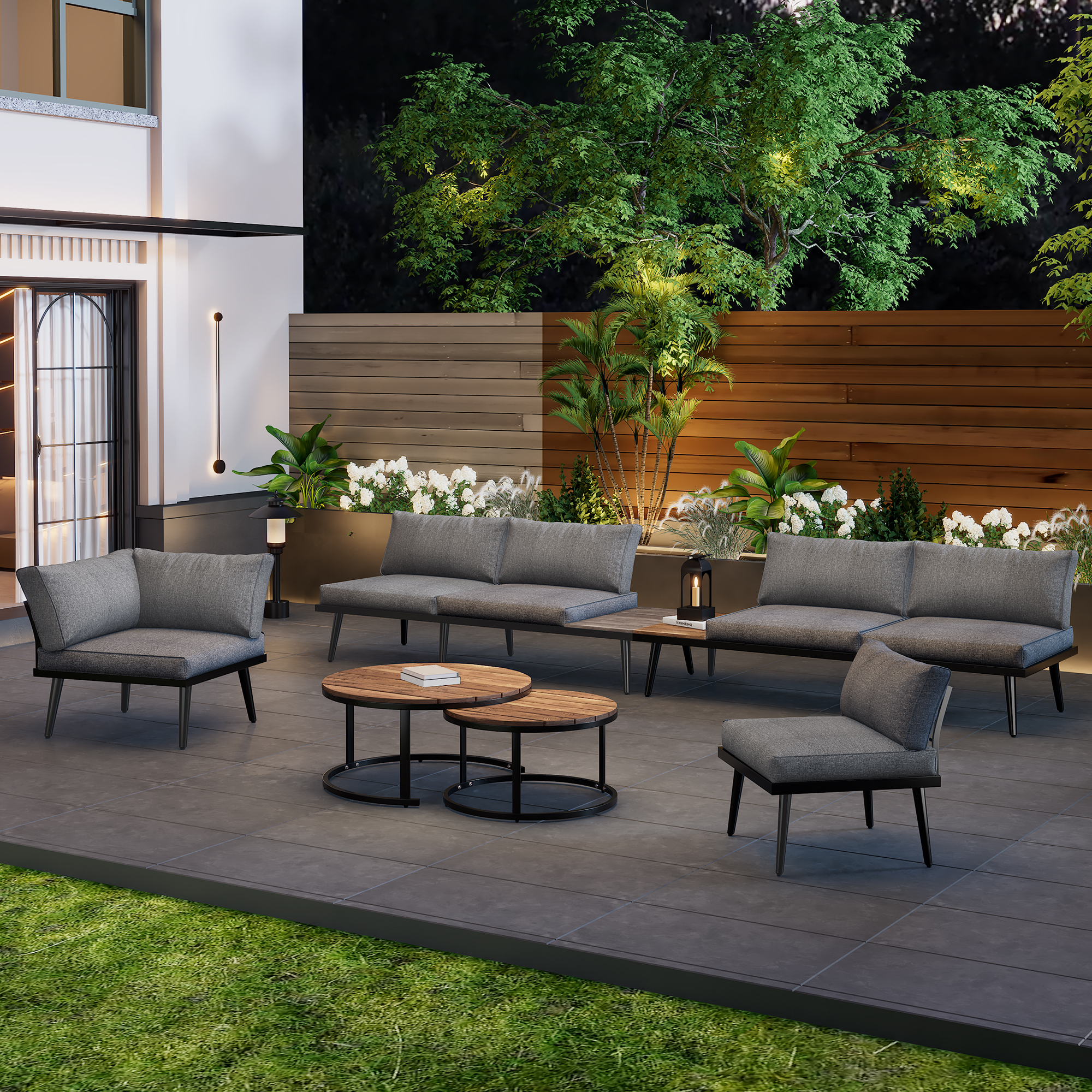 Terrassenmöbel-Set mit Sofas, Stühlen und Tischen. Grünes Gras und Nachthimmel.