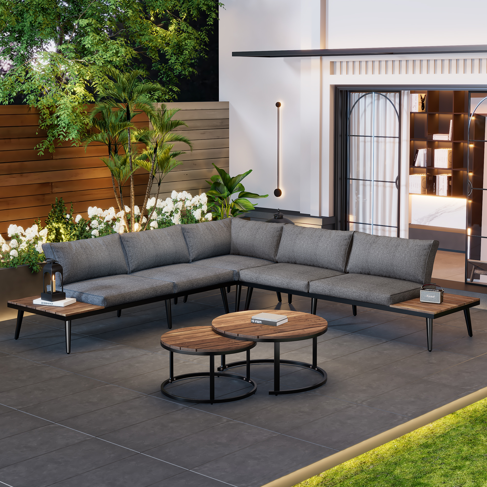 Outdoor-Ecksofa mit grauen Kissen, braunen Tischen und üppigem Hintergrund.