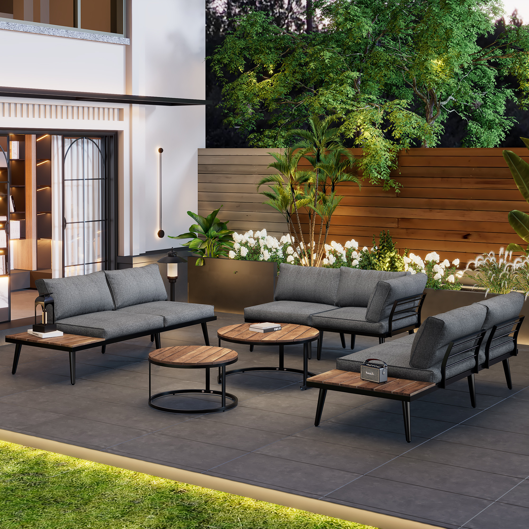 Outdoor-Terrassenmöbel-Set. Enthält Sofa, Stühle und Tische. Landschaftsbau und ein Haus im Hintergrund.