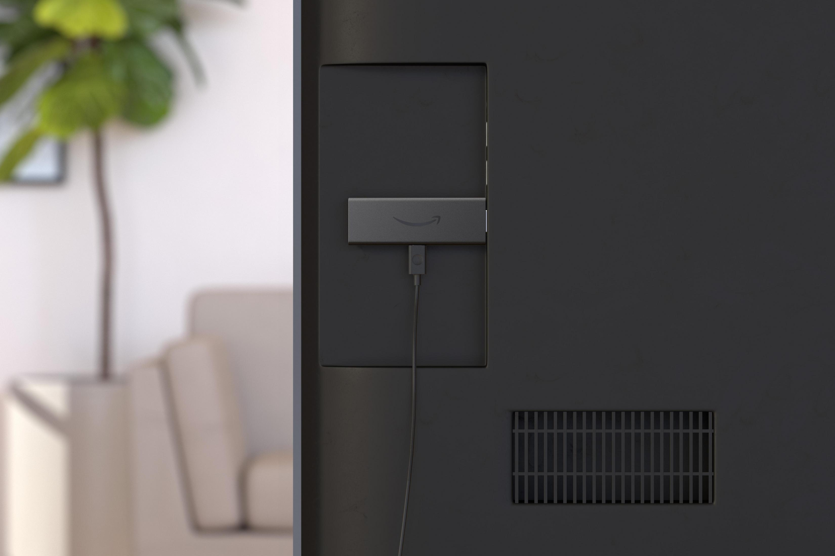 Parte trasera de TV con Fire Stick enchufado y habitación en el fondo.