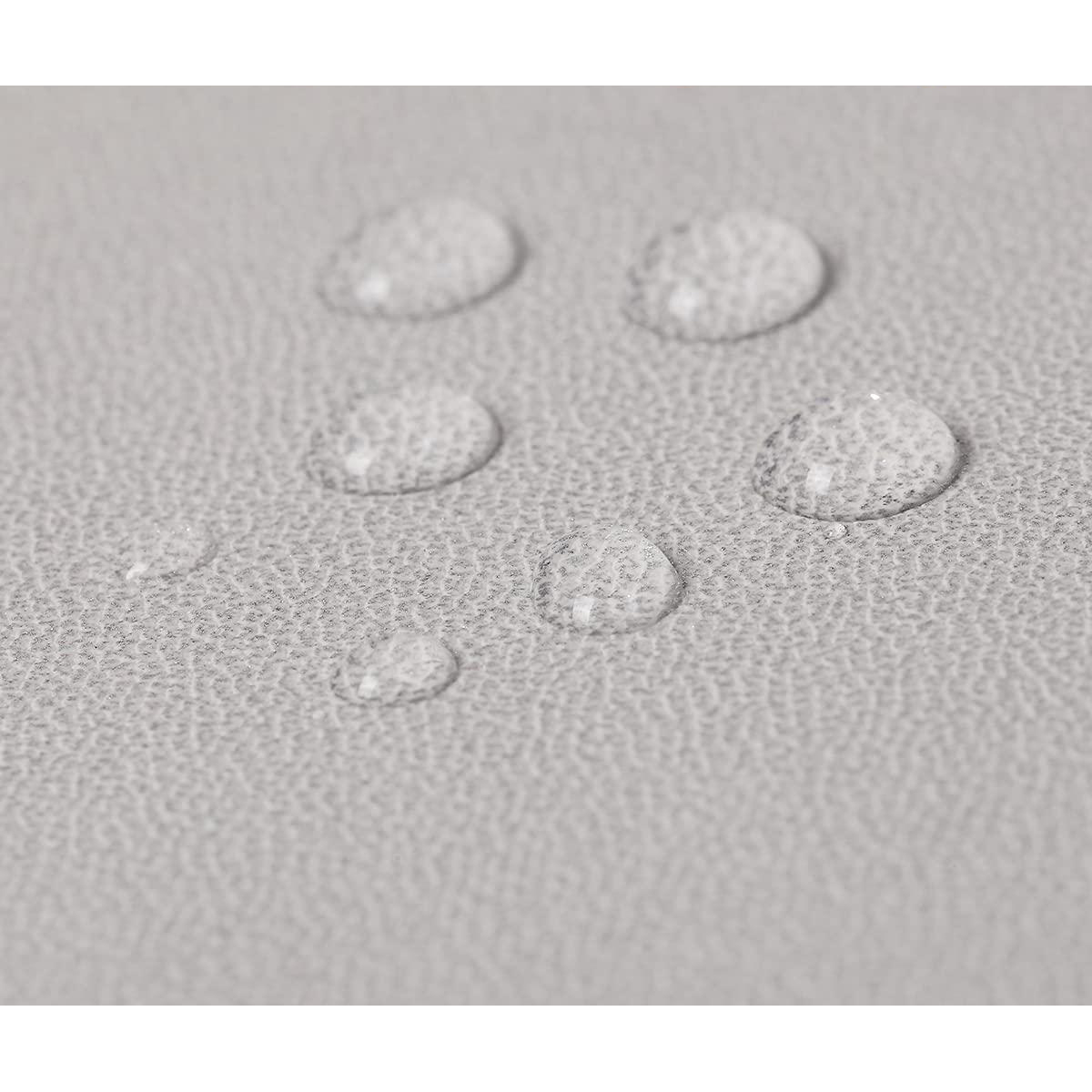 Gros plan de gouttes d'eau sur une surface grise texturée.
