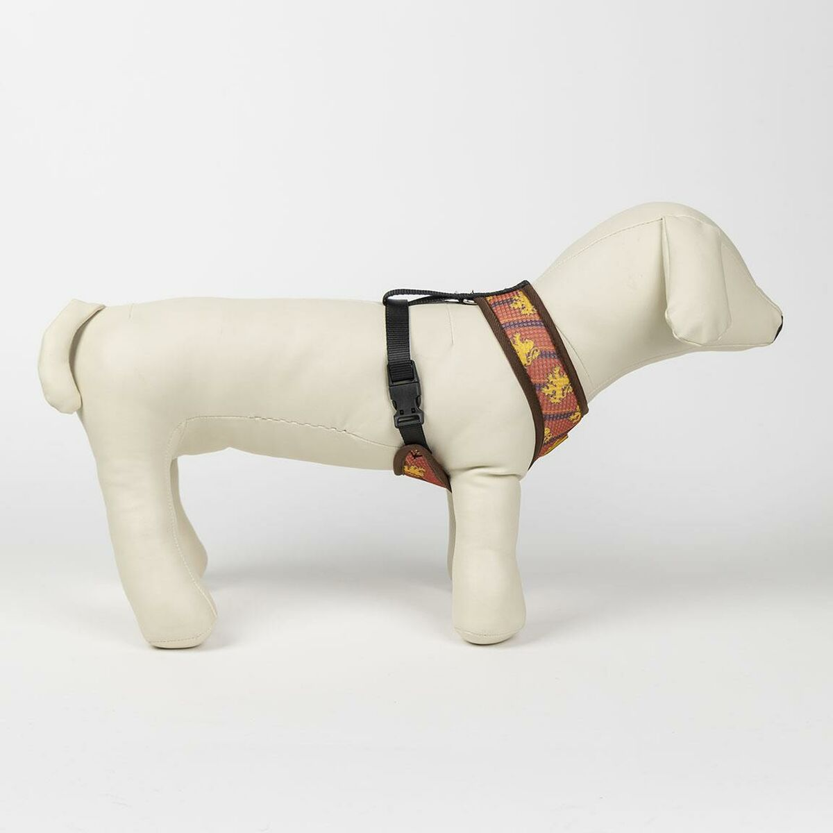 Un perro maniquí que lleva un arnés para perros con estampado marrón y amarillo con una hebilla negra.