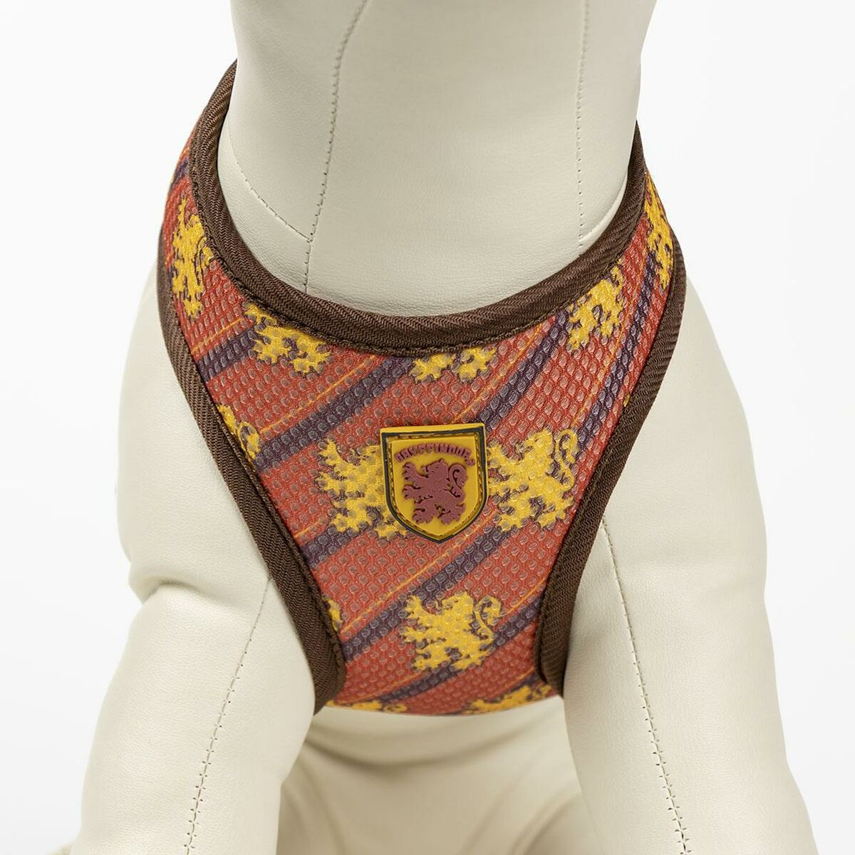 Hunde-Geschirr mit einem orange-gelben Muster und einem Wappen auf der Brust.