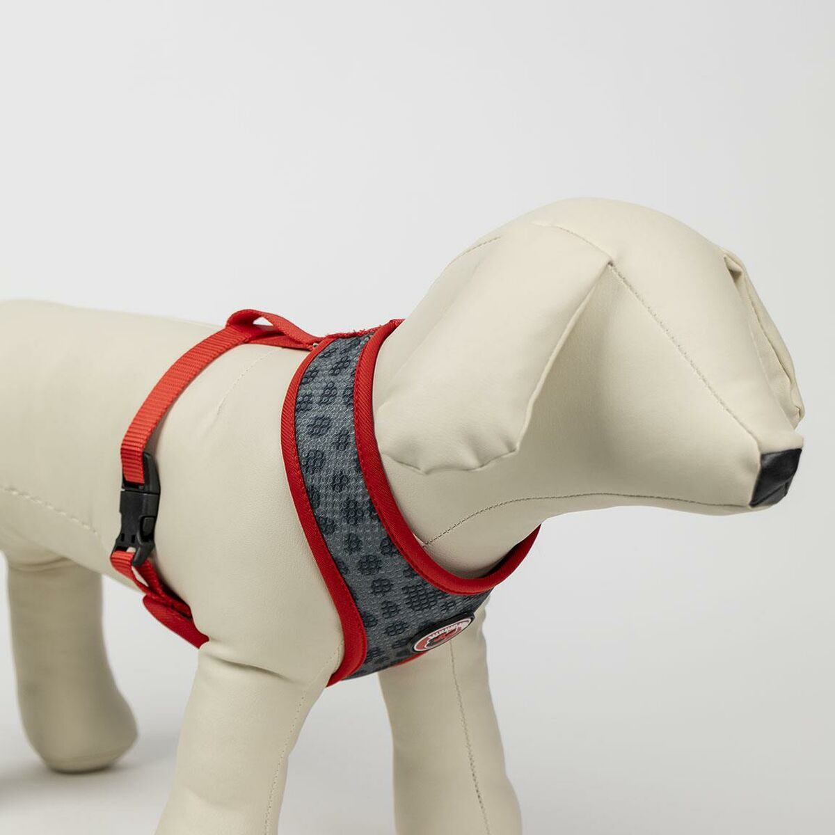 Hunde-Geschirr mit rotem Rand und grauem Muster, auf einer Schaufensterpuppe.