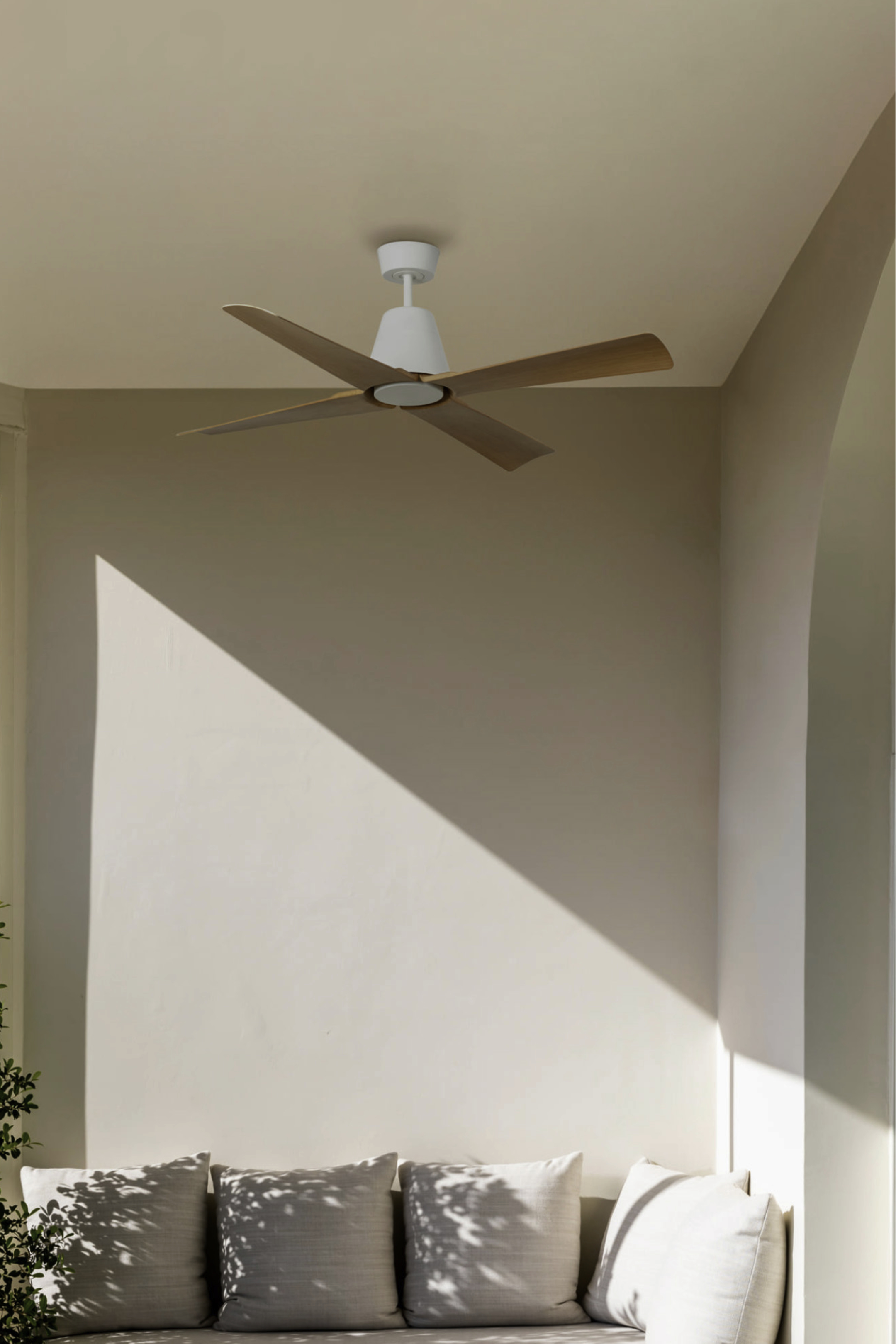 Deckenventilator mit Holzflügeln, weißer Motor. Beige Wände, natürliches Licht.