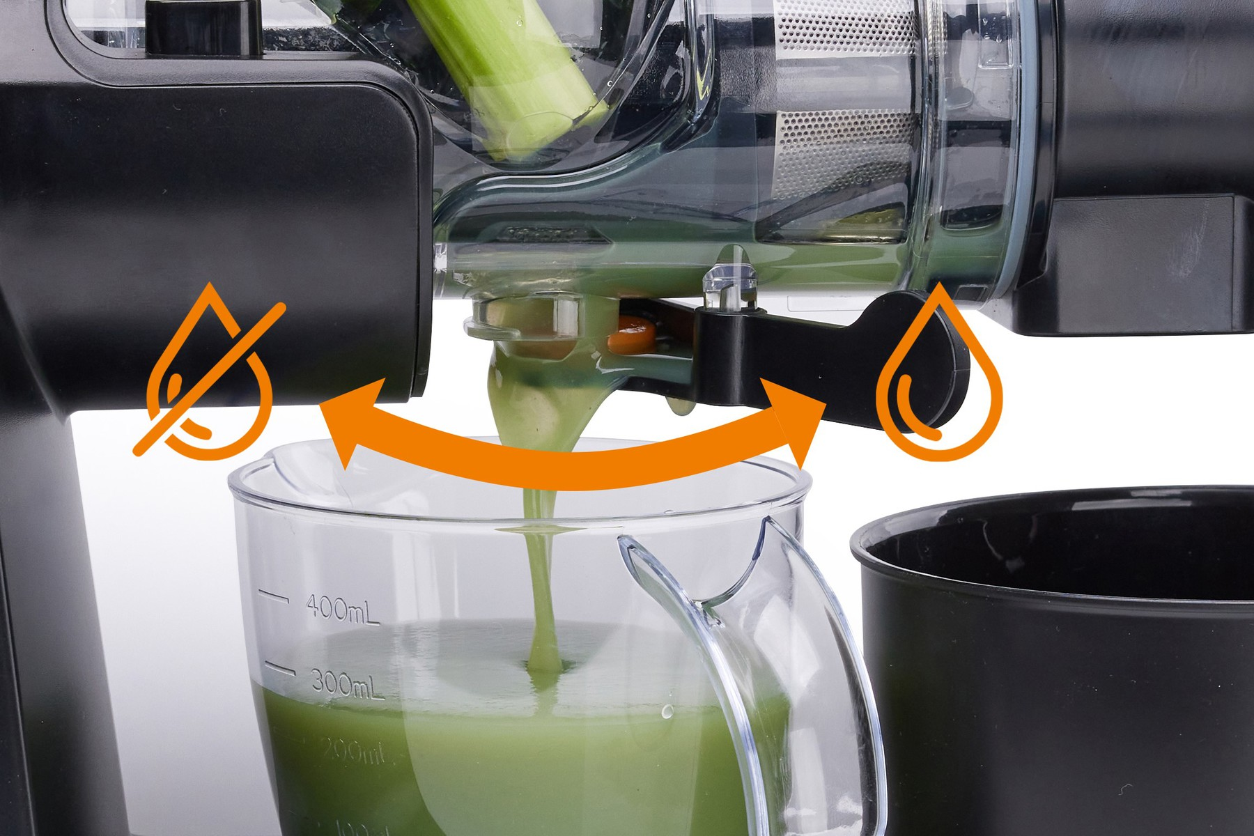 Ein Entsafter, der grünen Saft in einen Krug gießt. Pfeile zeigen den Saftfluss an. Teile des Entsafters und des Kruges sichtbar.