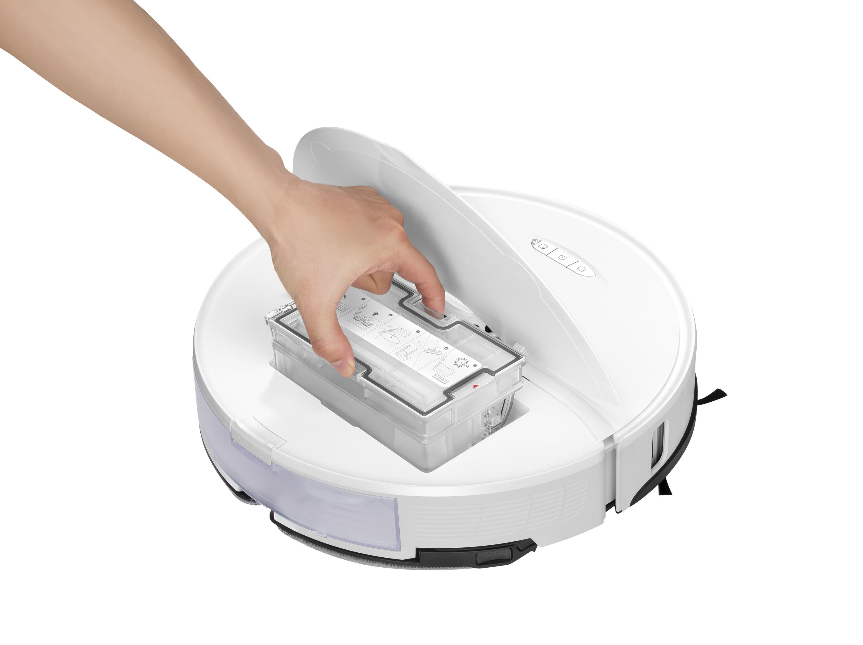 Una mano inserisce un contenitore trasparente in un aspirapolvere robotico bianco e rotondo. L'aspirapolvere è su una superficie bianca.