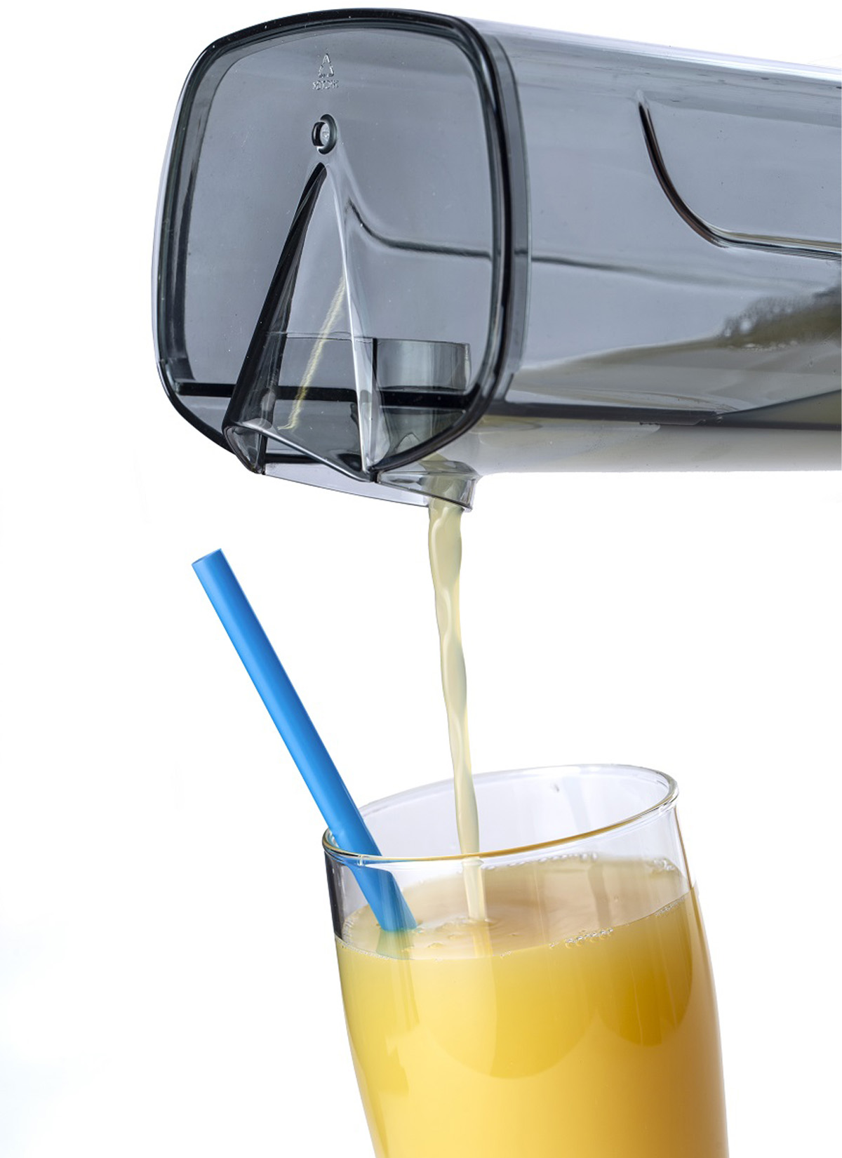 Una caraffa versa succo d'arancia in un bicchiere con una cannuccia blu.