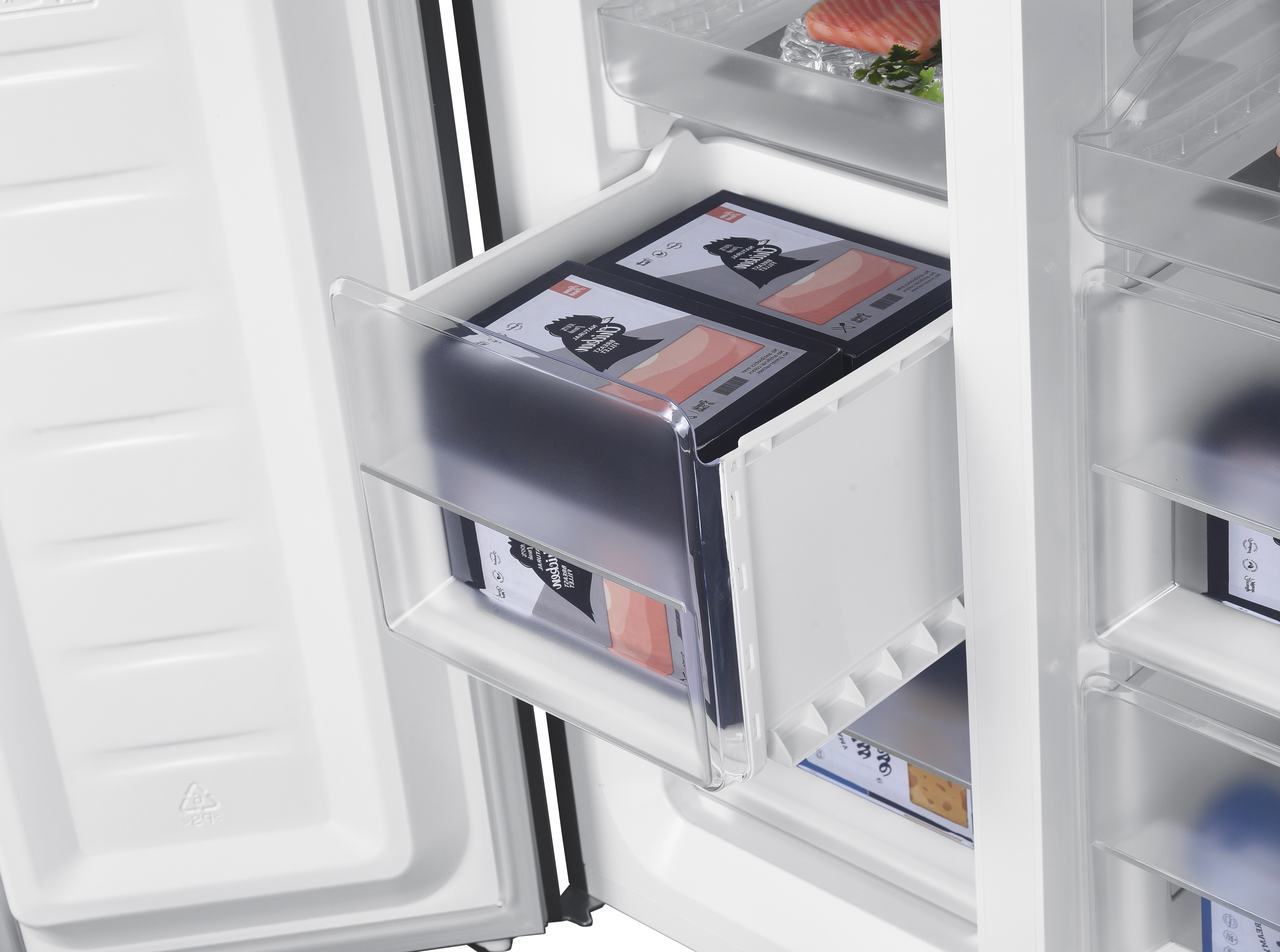 Refrigerator interior with a drawer holding food boxes. Clear plastic drawer and shelves.