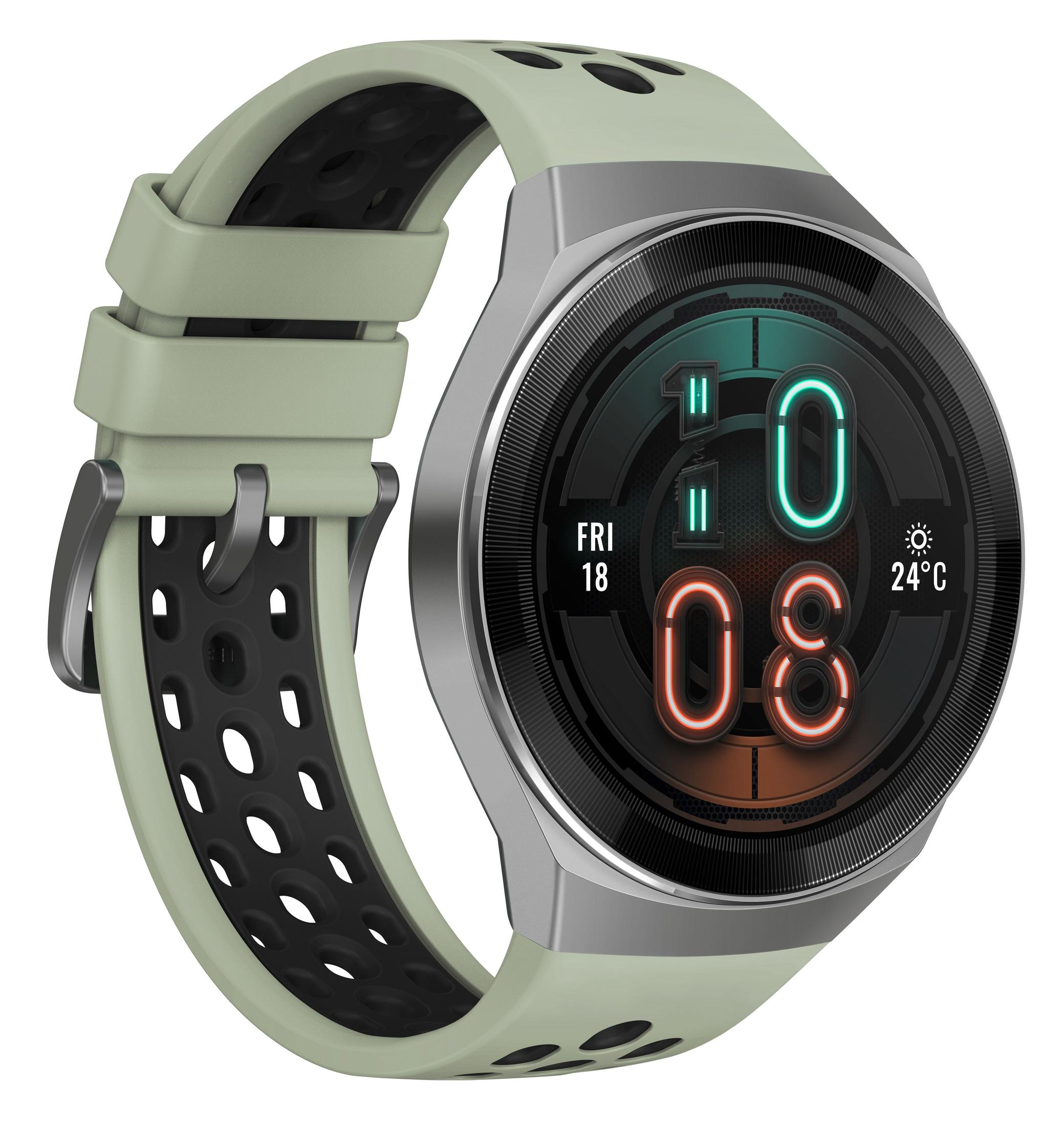 Okrągły smartwatch z zielonym paskiem i czarnym, perforowanym paskiem wewnętrznym. Ekran pokazuje czas.