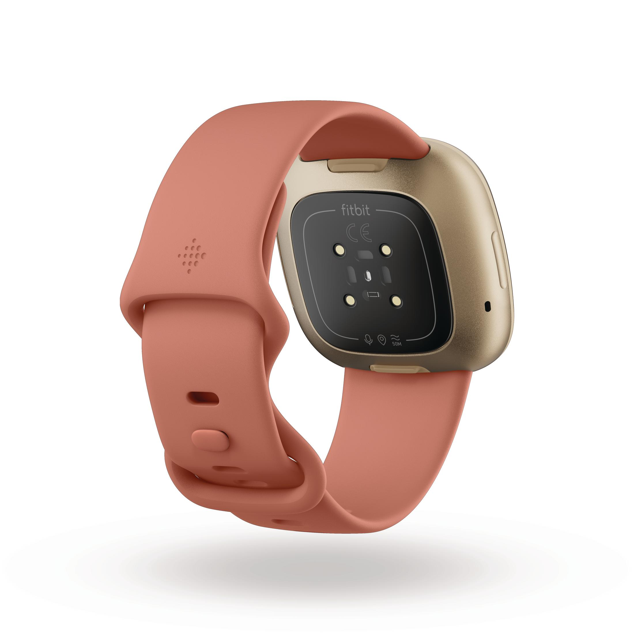 Pink Fitbit Versa 3 smartwatch, showing the back. Pink strap and gold-colored watch face are visible.