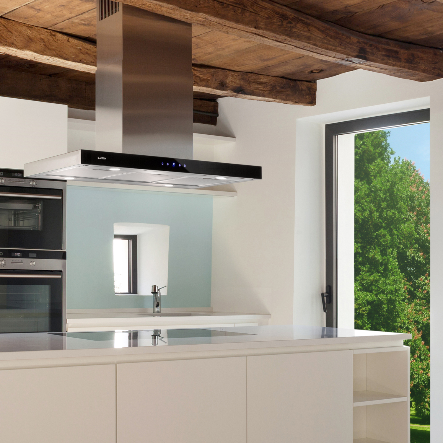 Una cocina con campana extractora de acero inoxidable, armarios blancos y una ventana con vistas verdes.