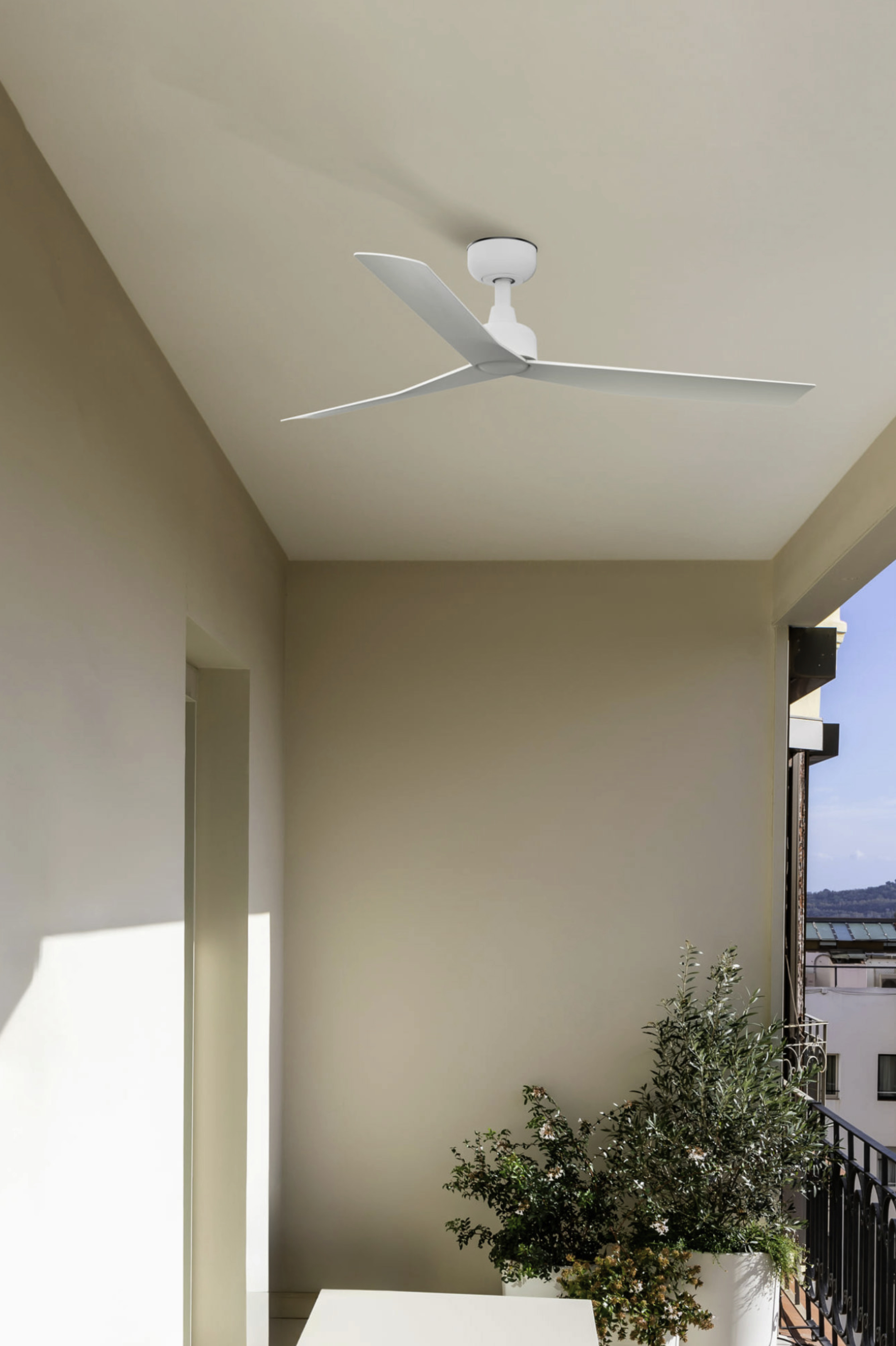 Ventilatore da soffitto bianco con tre pale installato su un soffitto bianco.