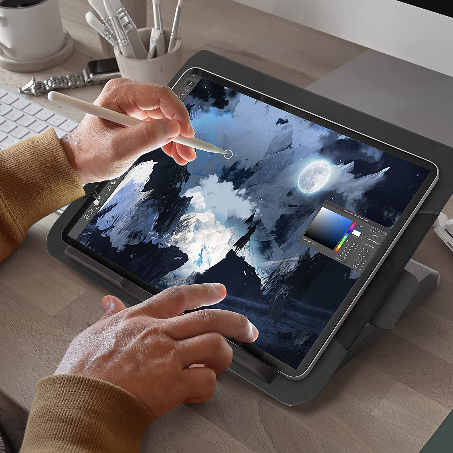 Person benutzt Stift auf Tablet, auf Ständer auf Holztisch.