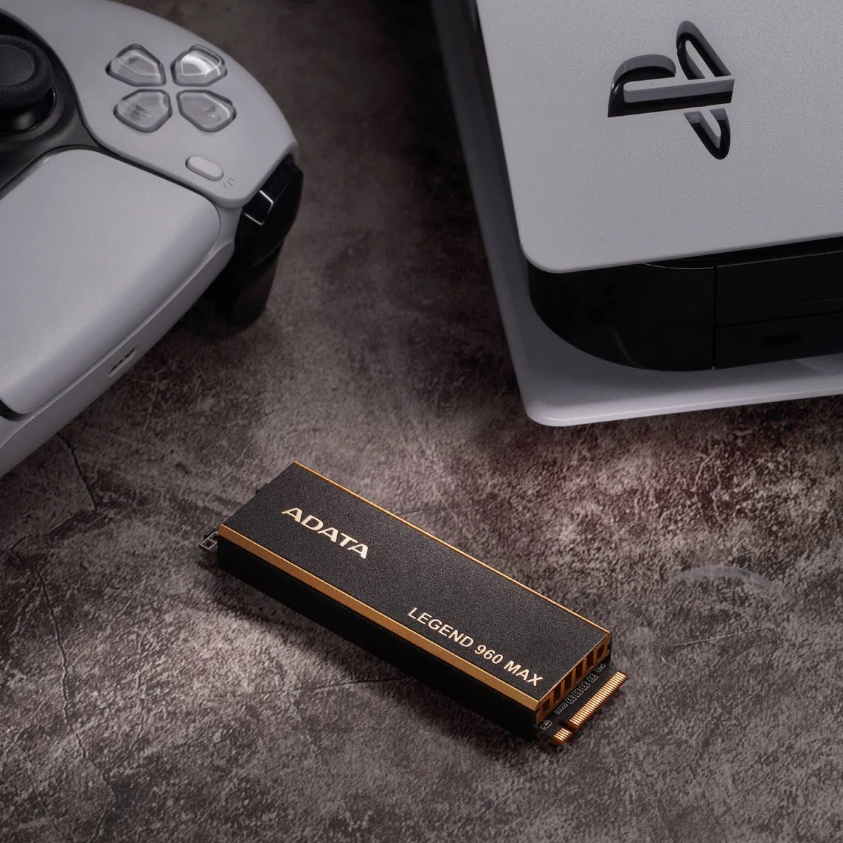 Dysk SSD ADATA Legend 960 MAX i konsola PlayStation 5 na wzorzystej powierzchni.