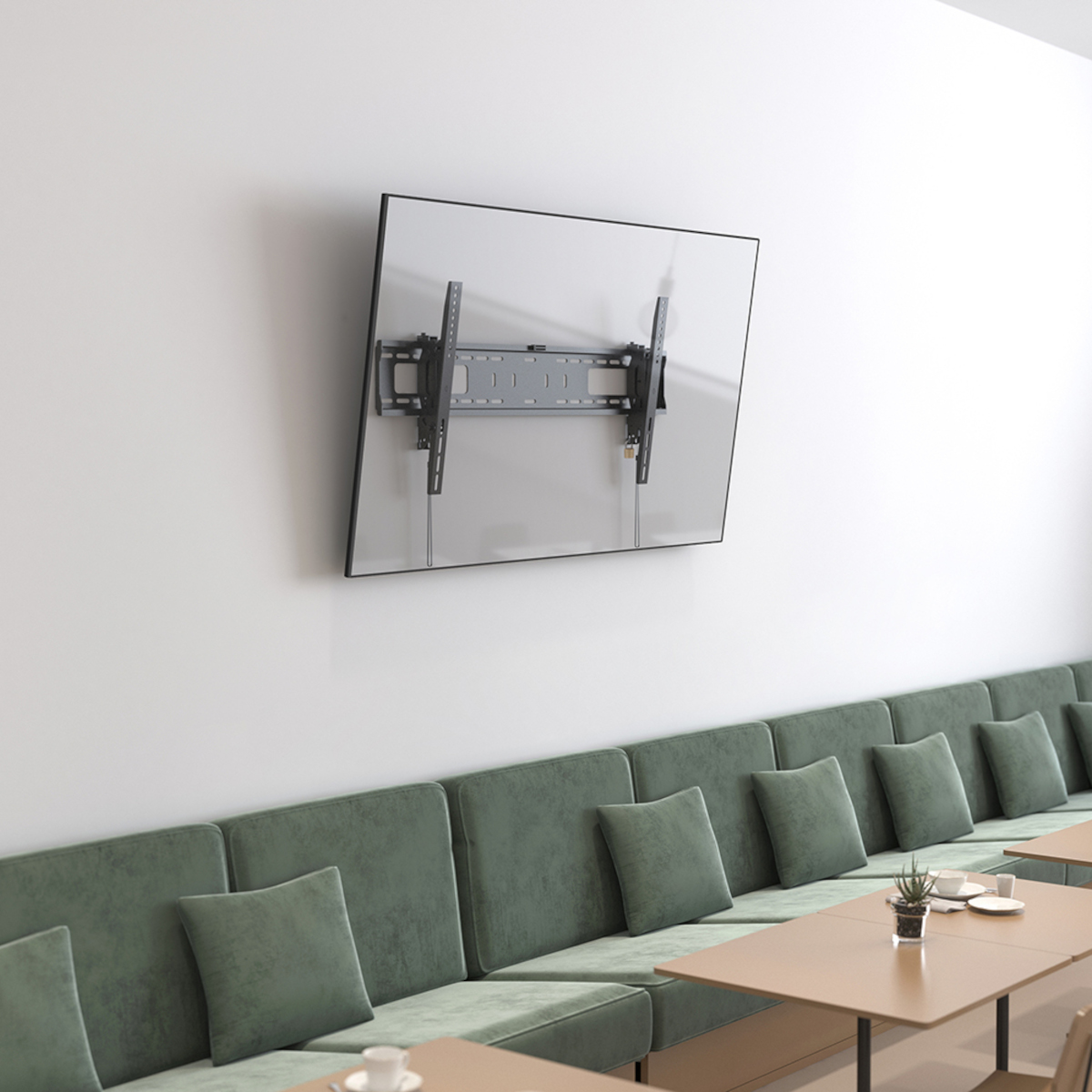 Fernseher mit Halterung an der Wand montiert. Im Hintergrund ein Sitzbereich.