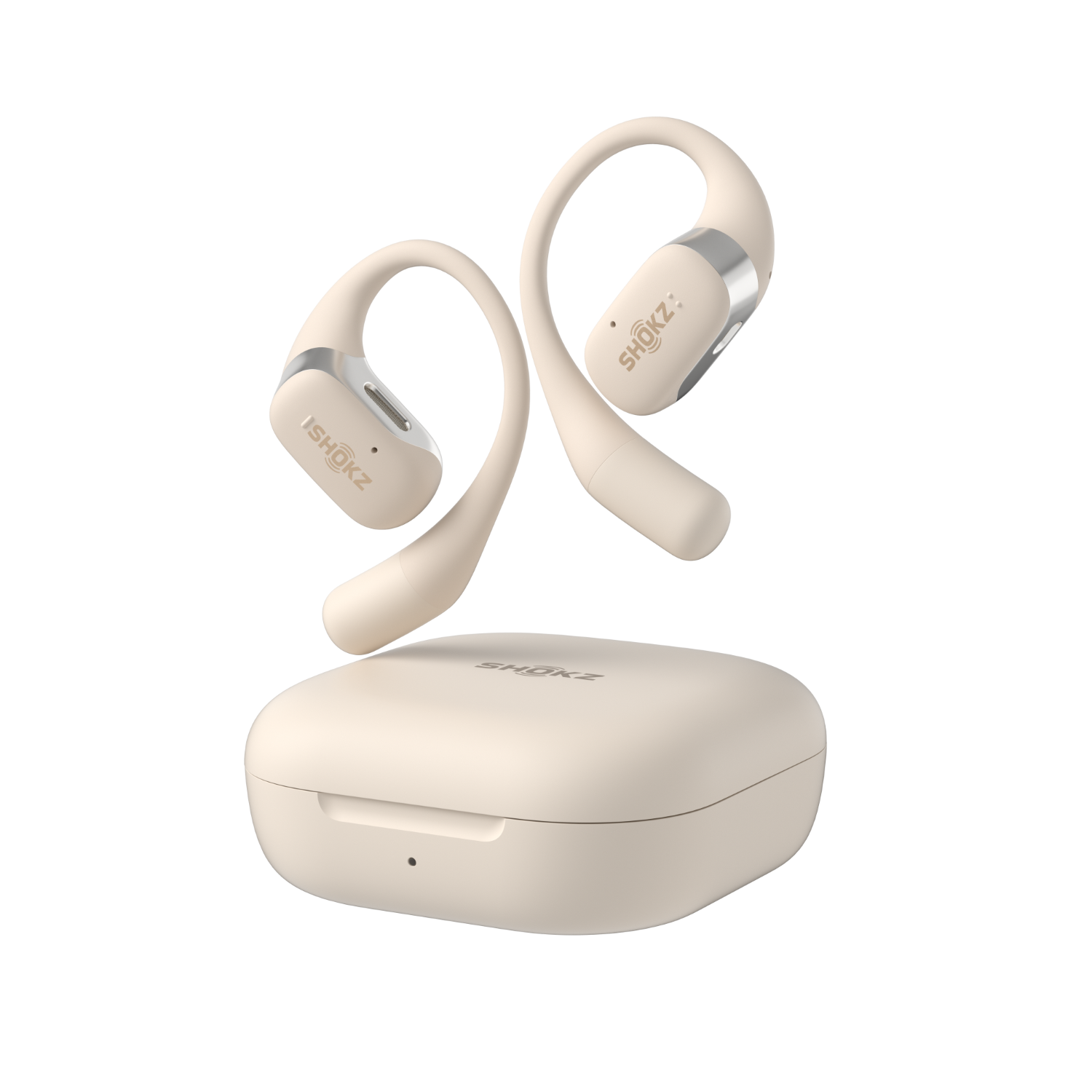 Dwa kremowe, zakrzywione słuchawki douszne z pasującym etui ładującym. Białe tło.