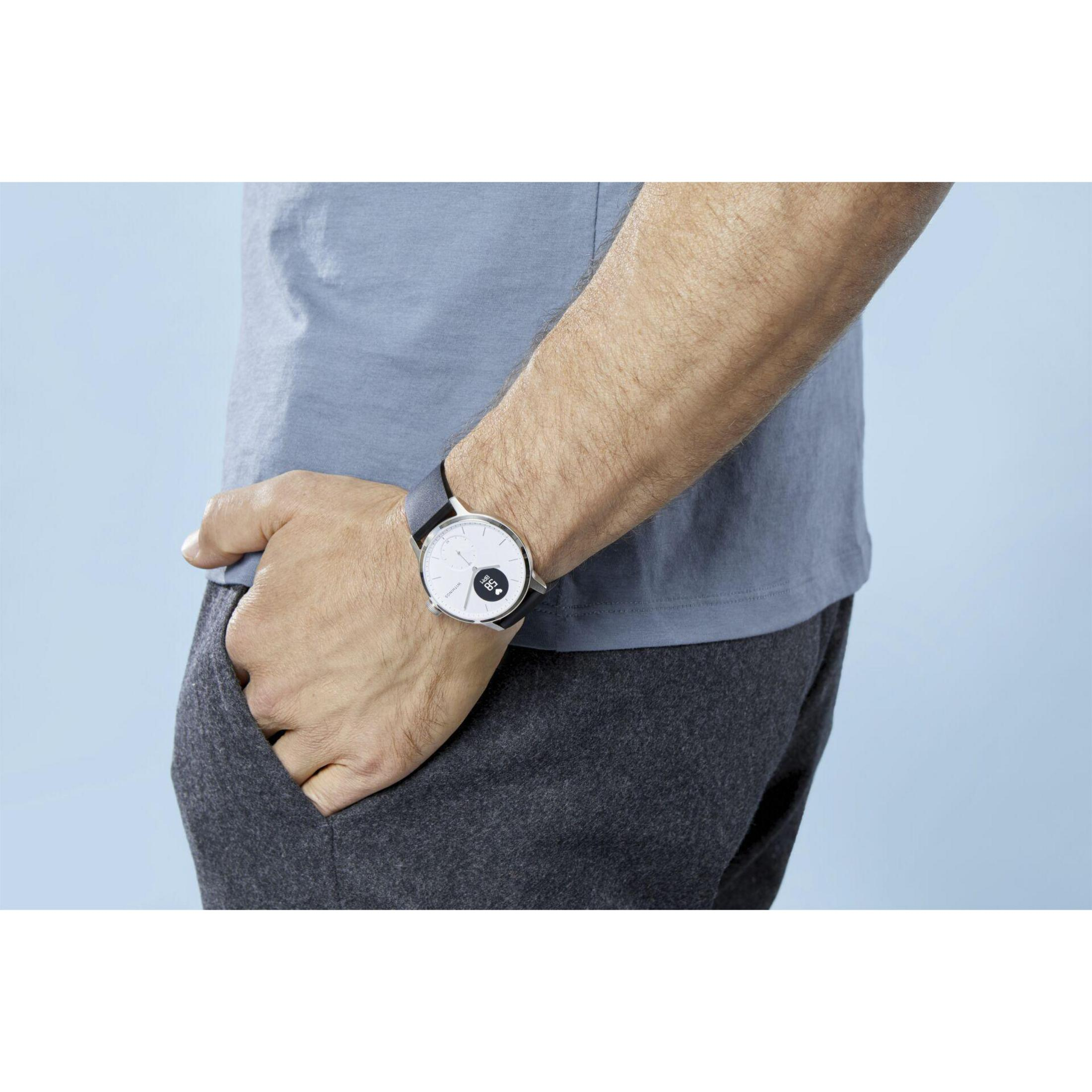 Mann mit Uhr. Arm in grauem Hemd, Hand in der Tasche, Uhr mit weißem Zifferblatt.