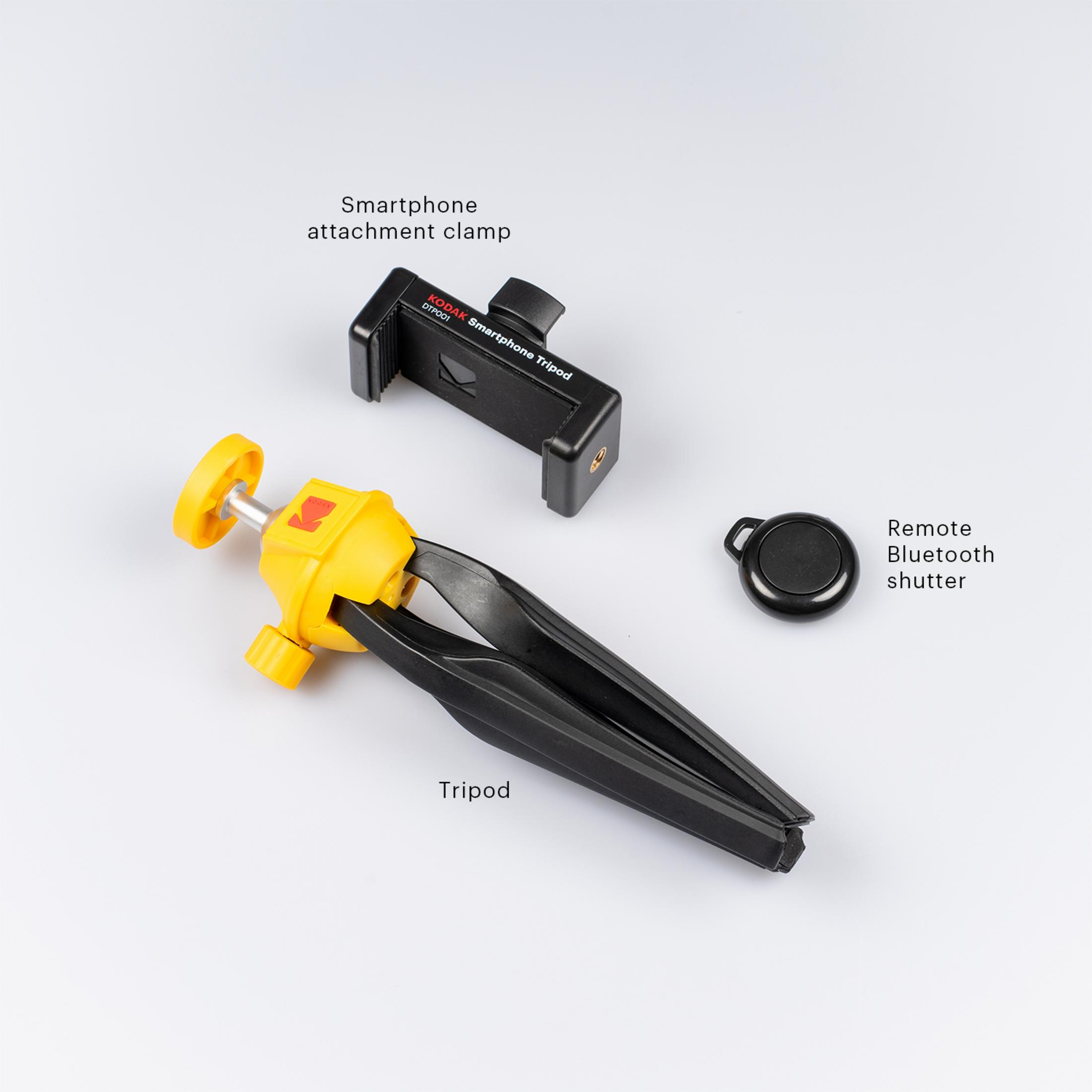 Trípode con accesorio para smartphone y disparador remoto. Trípode negro y amarillo sobre superficie blanca.