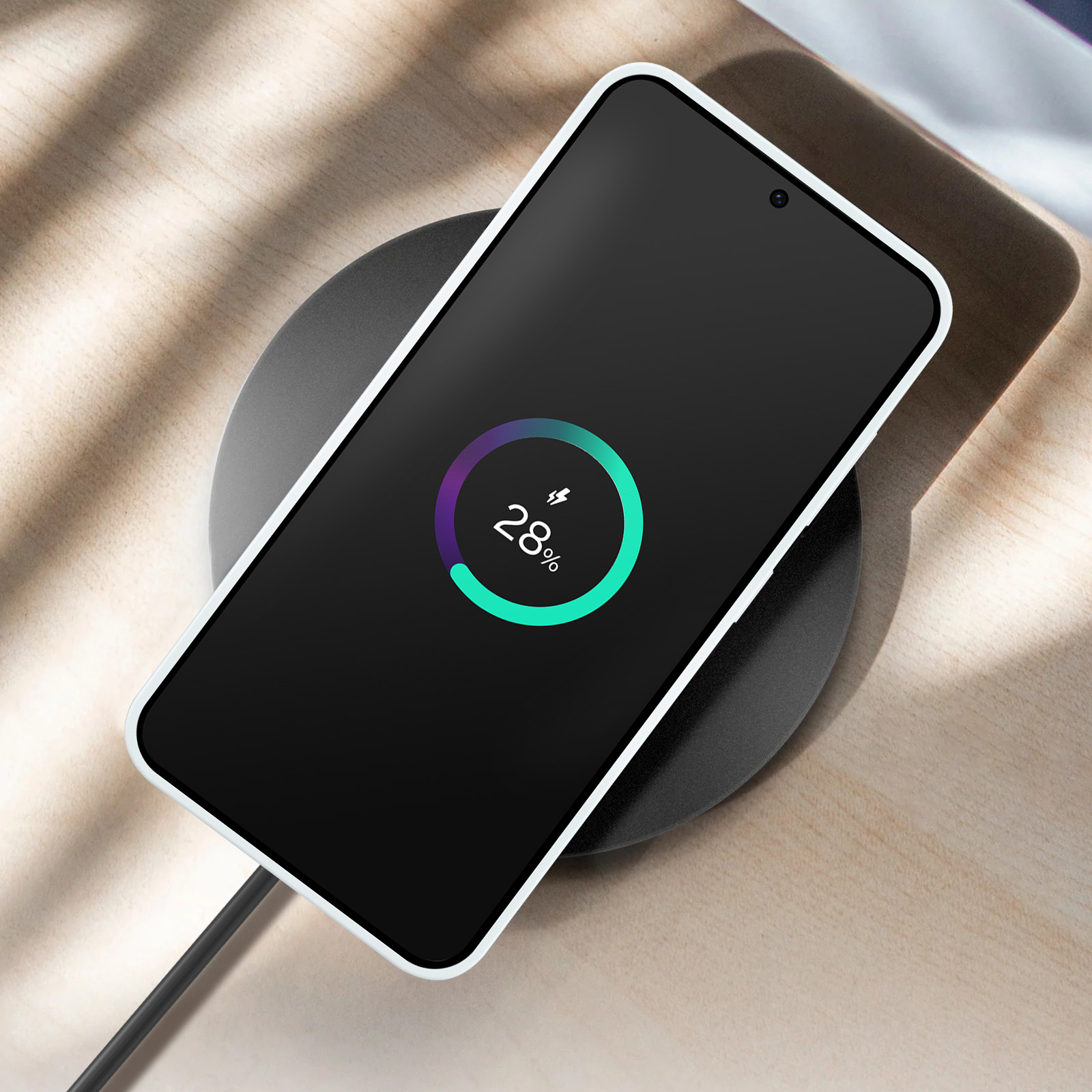 Zwarte telefoon op draadloze oplader. Oplaadindicator toont 28%.