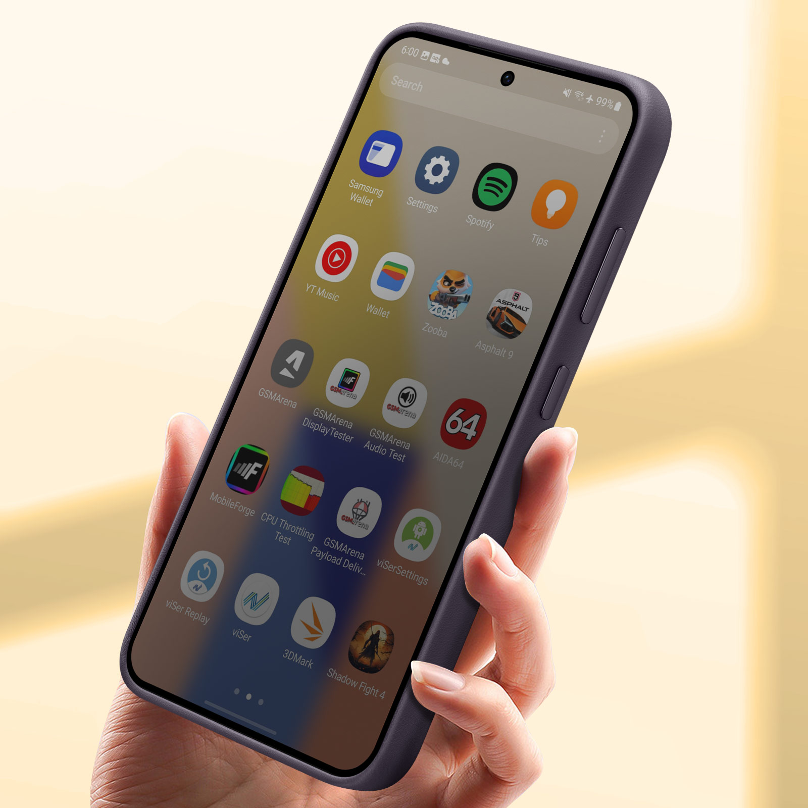 Hand hält ein lila Smartphone mit Apps auf dem Bildschirm. Gelber Hintergrund.