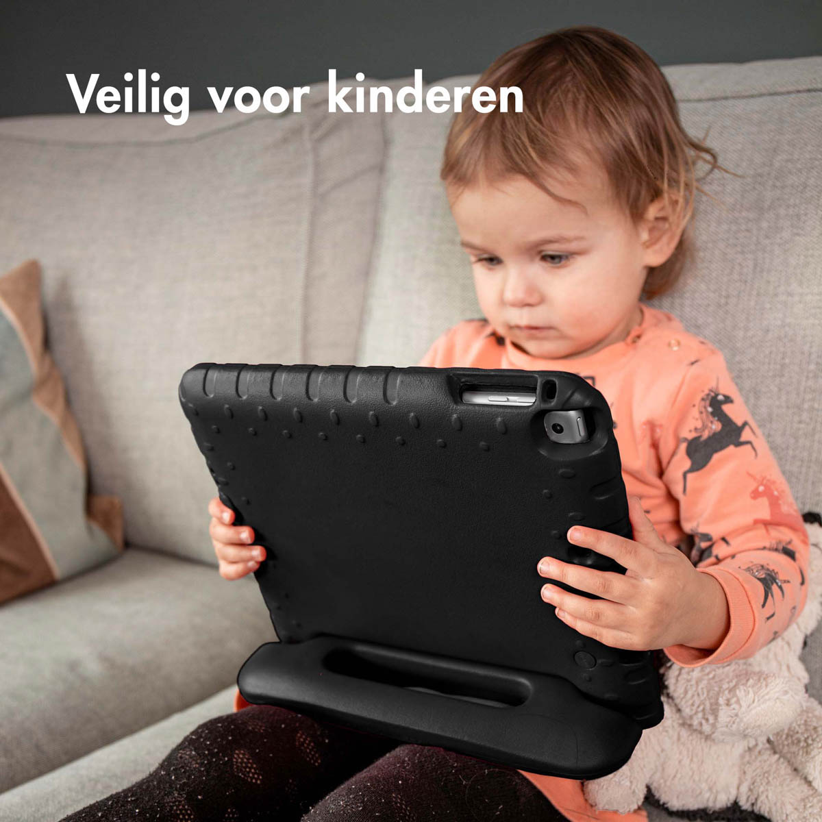 Jeune enfant tenant un étui de tablette noir.