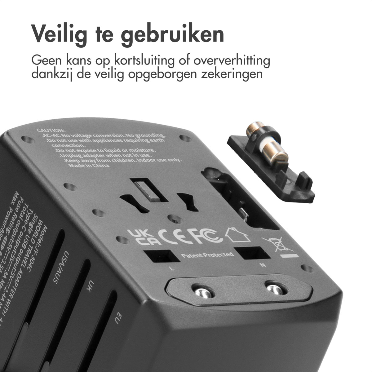 Een zwarte reisadapter met verwijderbare zekering en diverse landaanduidingen.
