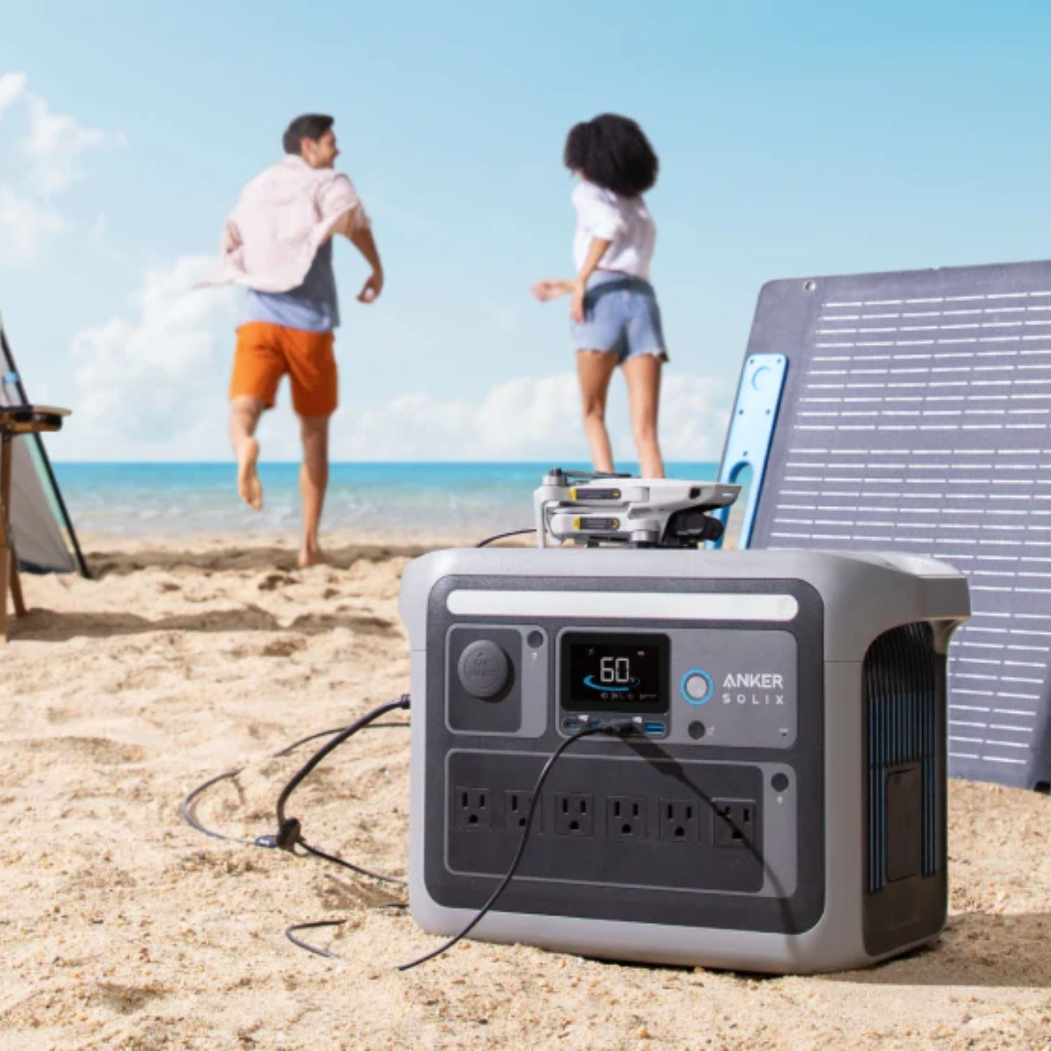 Dwie osoby na plaży z elektrownią i panelem słonecznym.