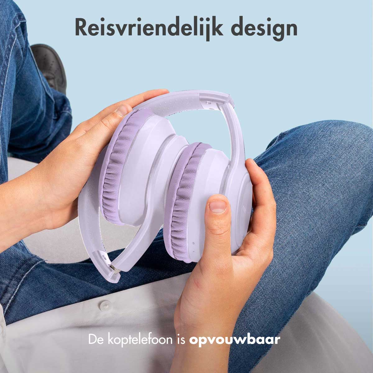 Hands holding foldable white and purple headphones, set against a blue background.