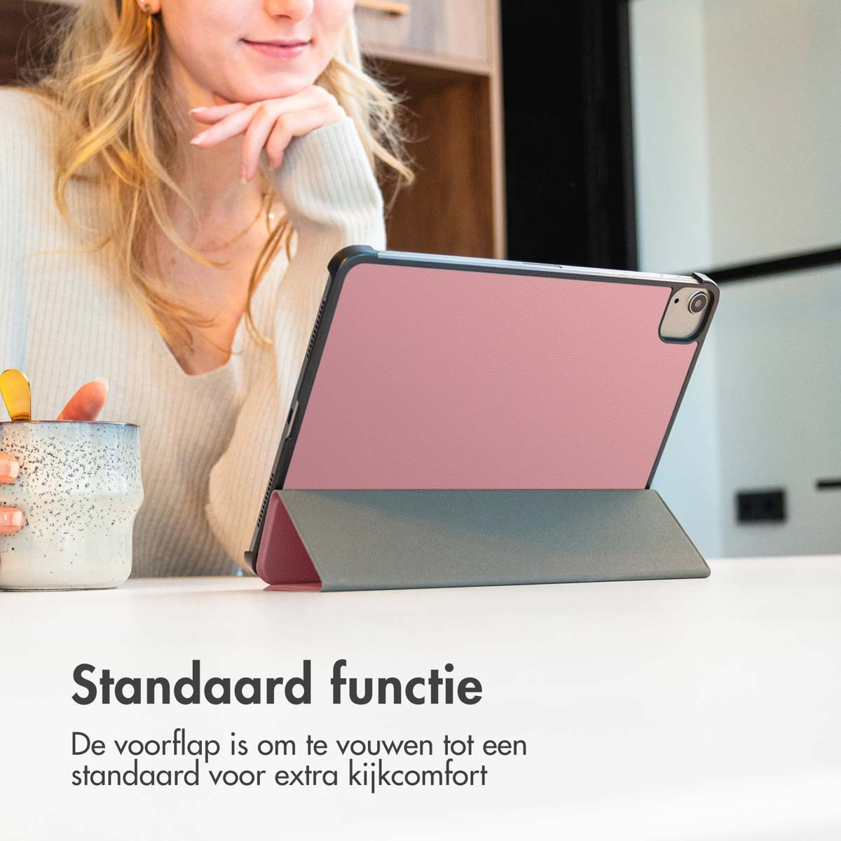 Woman with pink tablet case. Pink case, grey stand. White table, neutral background, product shot.