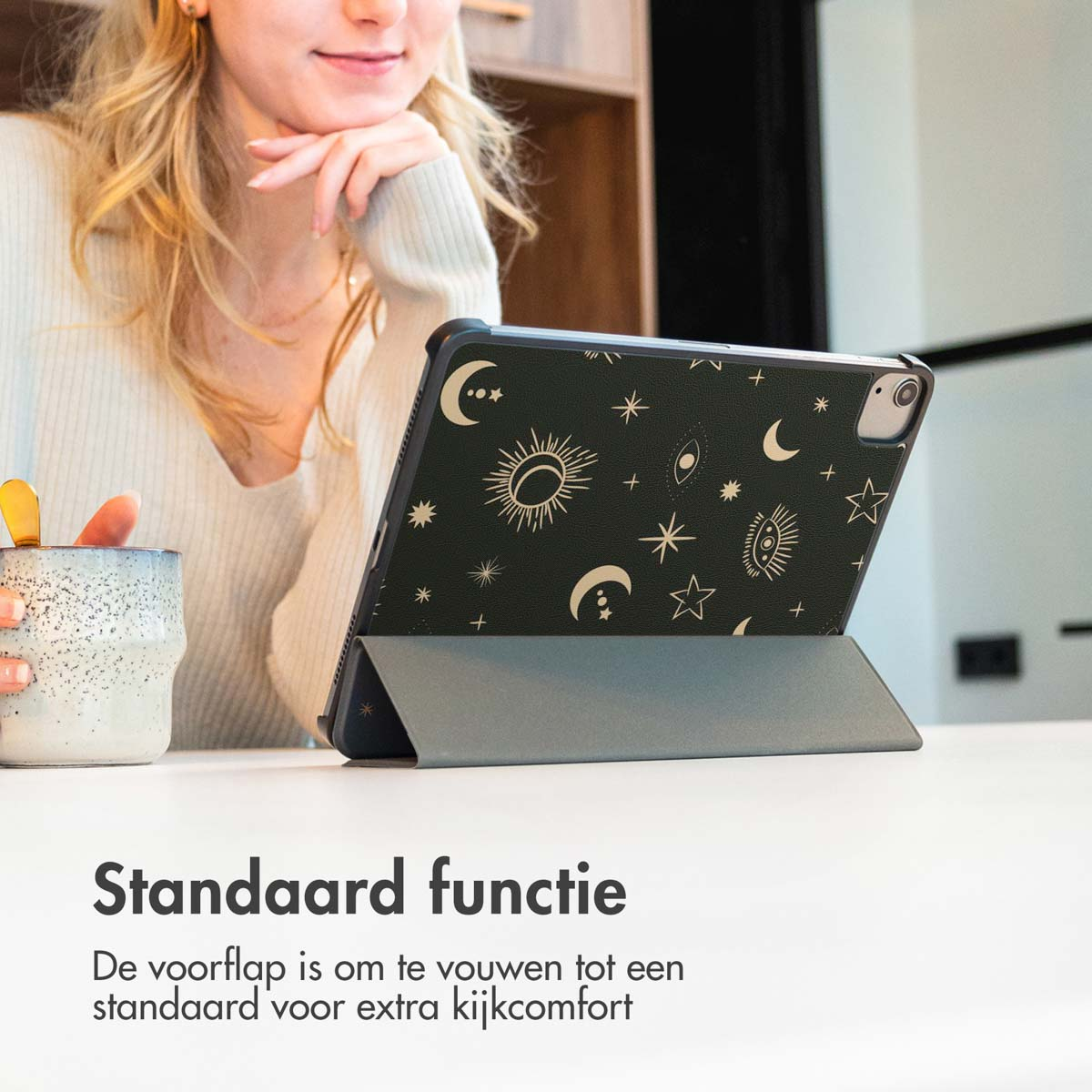 A woman with a tablet in a case with a stand function. The case has moons and stars.