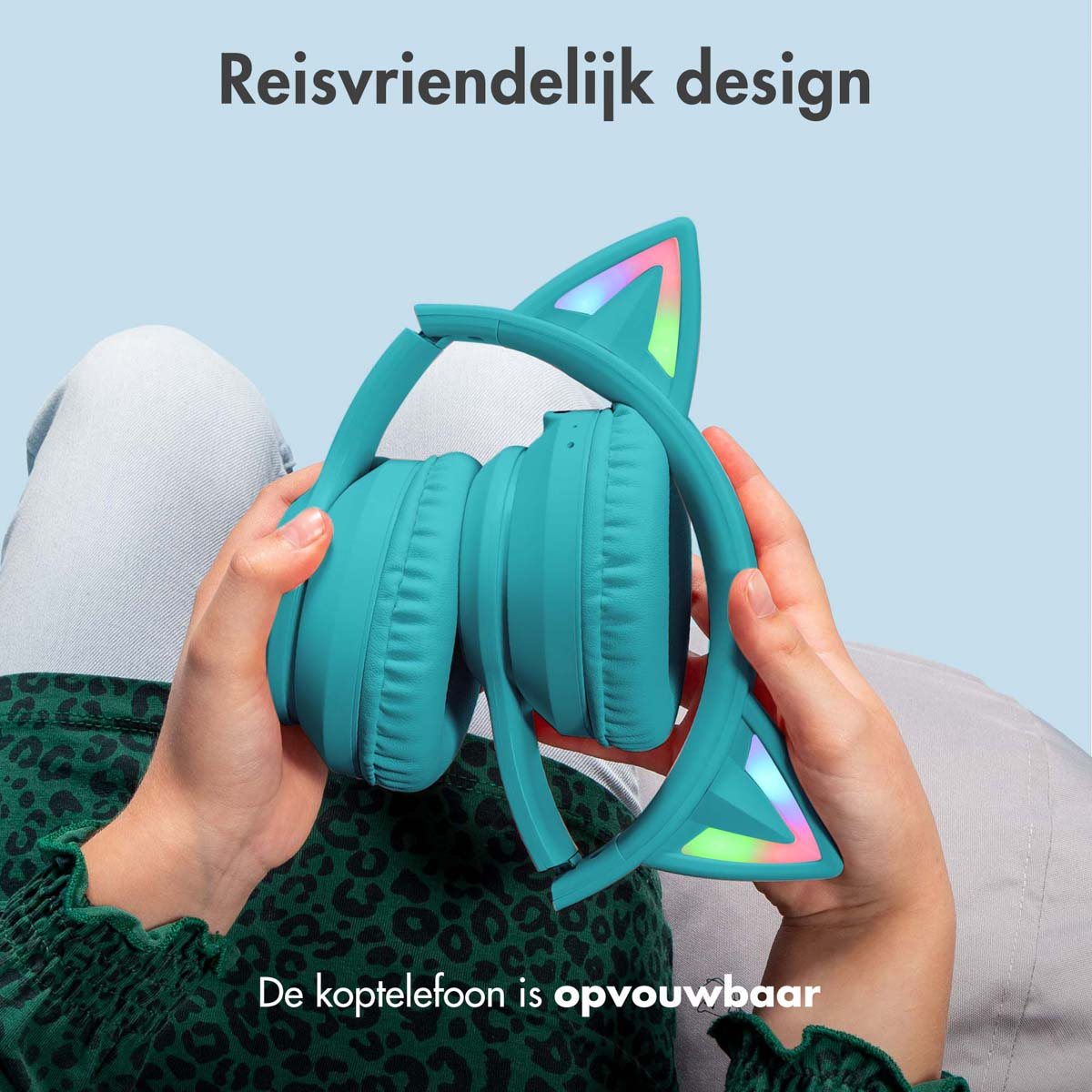 Hoofdtelefoon met kattenoren, vastgehouden door handen. De hoofdtelefoon is opvouwbaar en turquoise.