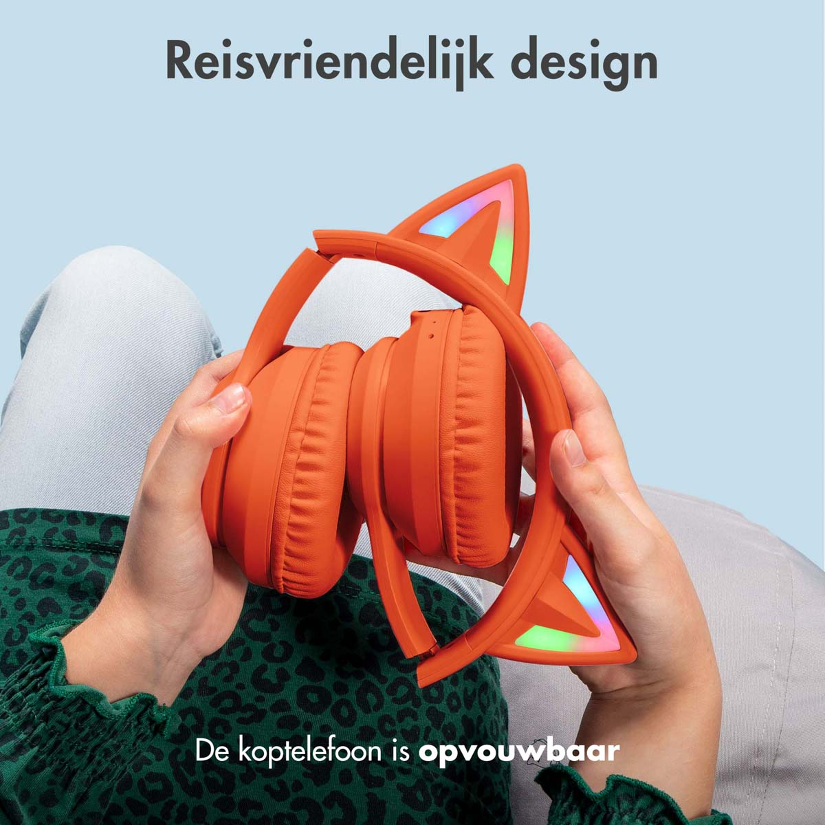 Opvouwbare oranje koptelefoon met kattenoren. Tekst: Reisvriendelijk ontwerp.