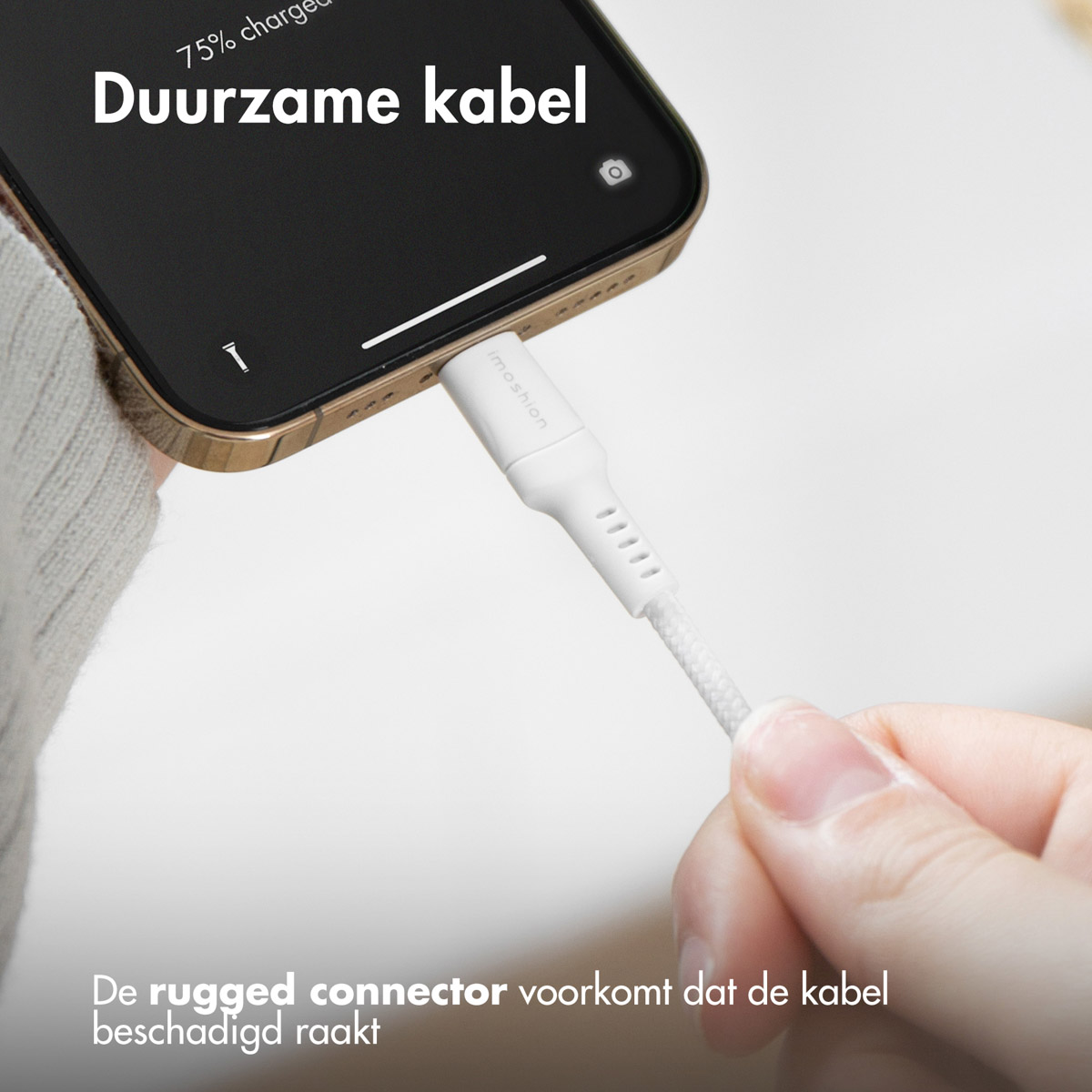 Un câble de chargement blanc est branché sur un smartphone doré.